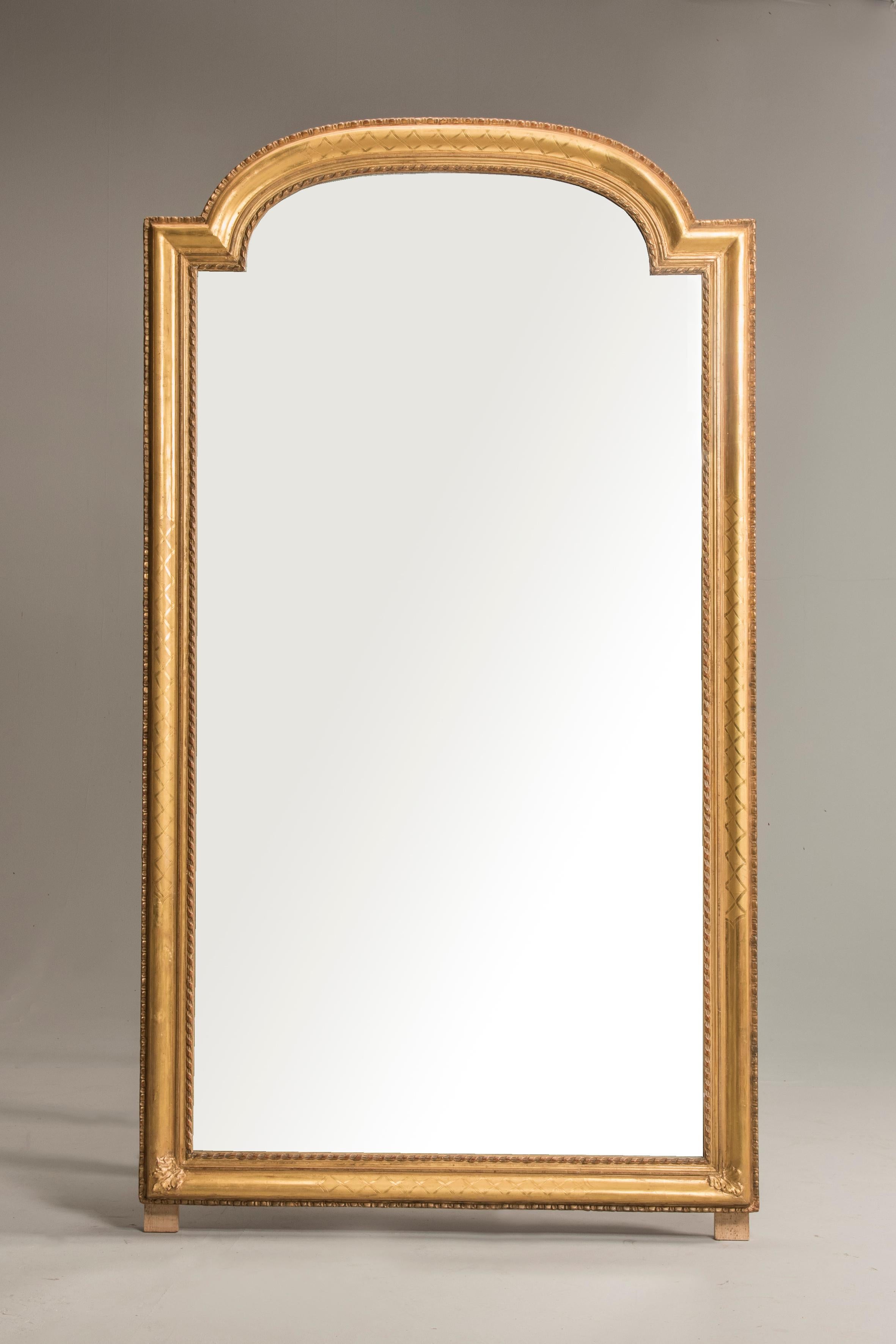 Mid-19th century Louis Philippe mirror, giltwood frame from France from 1840-1860 period. Its original silvered mirror is the most appreciable detail together with the precious gold foil decorating the frame. The wood frame is gentle engraved and
