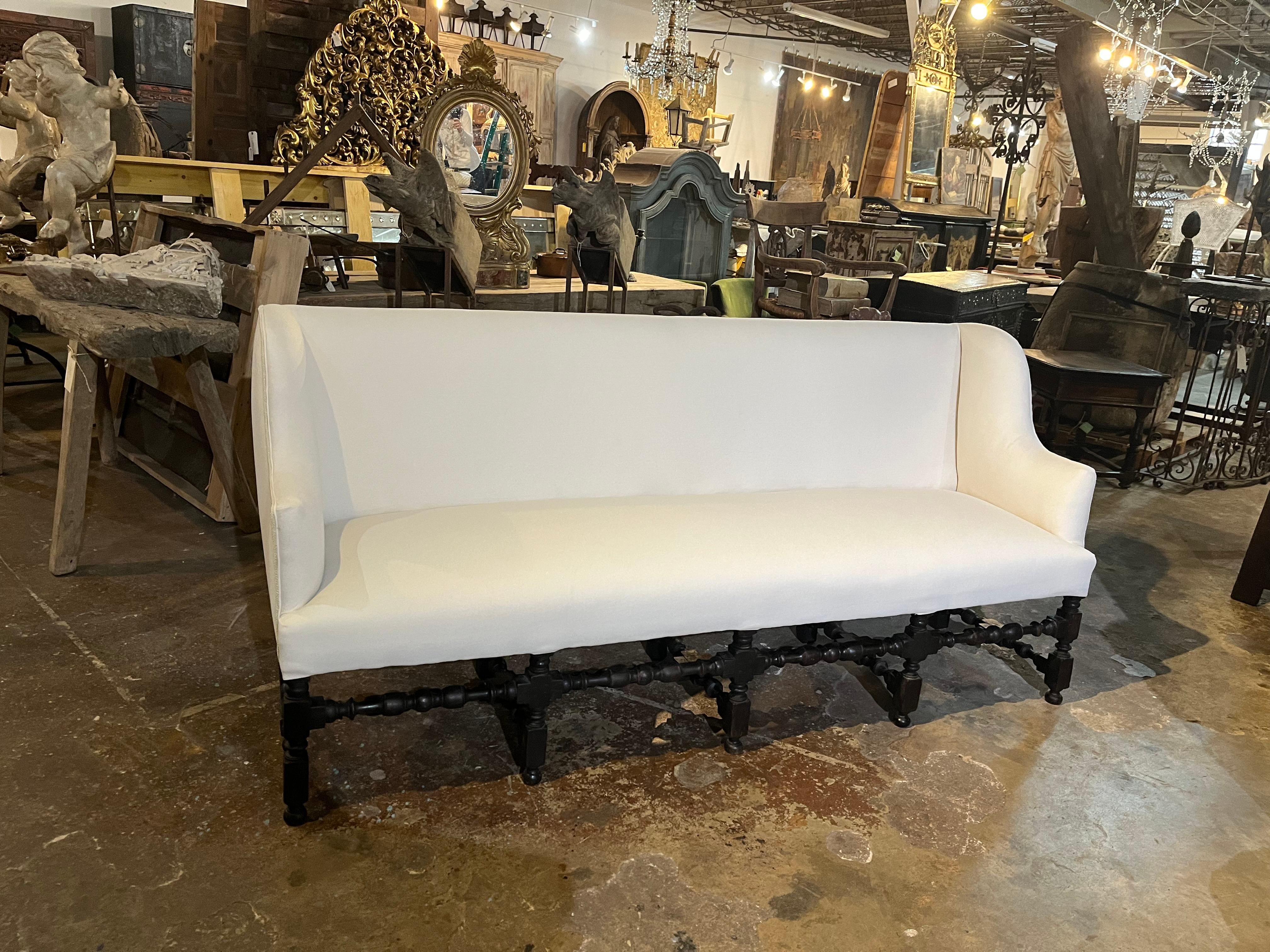 A very handsome Mid-19th Century French Louis XIII style settee - sofa. Soundly constructed from richly ebonized oak and recently reupholstered. The seat is supported by four beautifully turned front legs connected by turned center stretchers to the