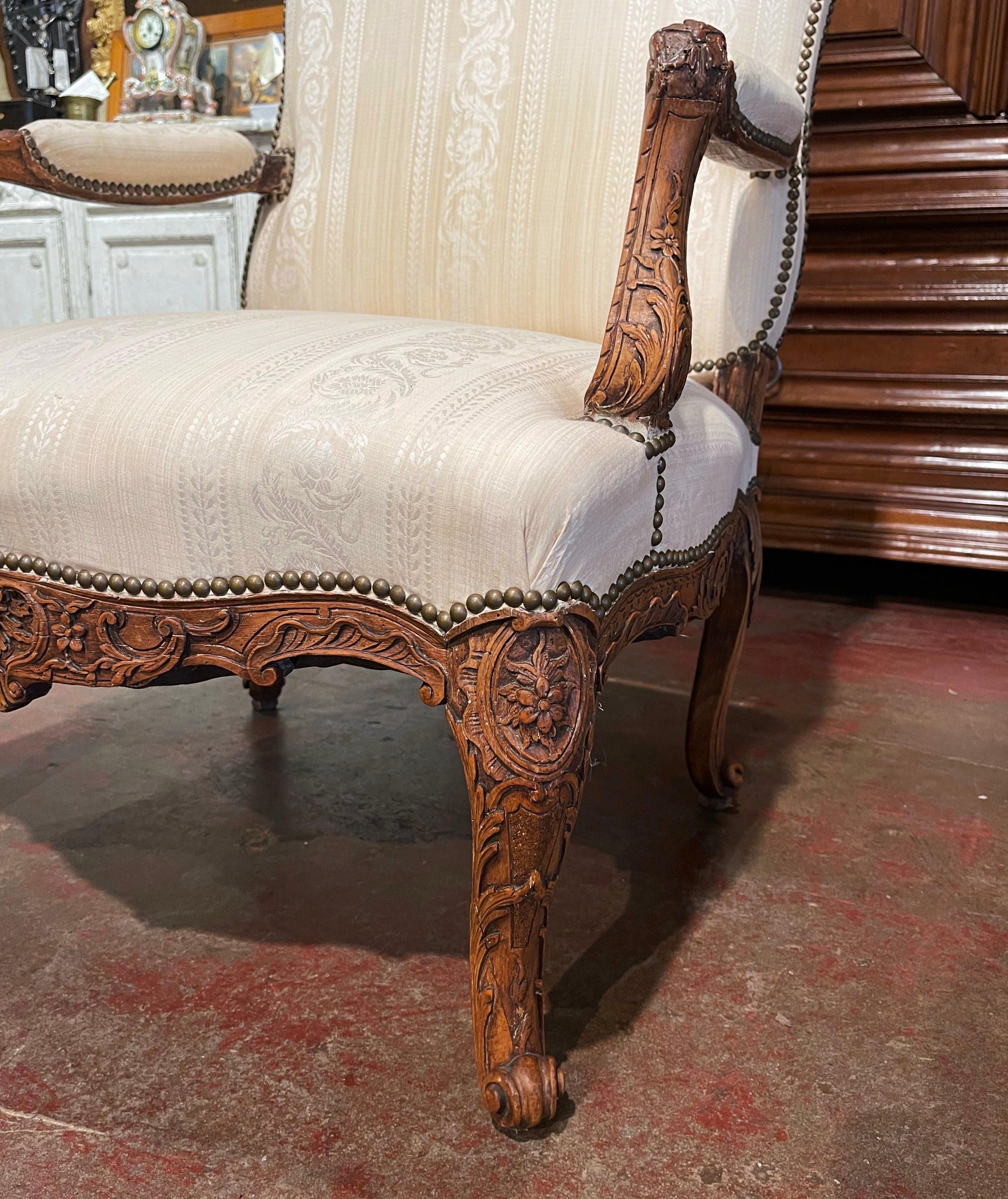 Decorate a study or a bedroom with this elegant antique armchair. Crafted in southern France circa 1860, the comfortable fauteuil sits on cabriole legs decorated with acanthus leaves at the shoulder and ending with escargot feet. The armchair has a