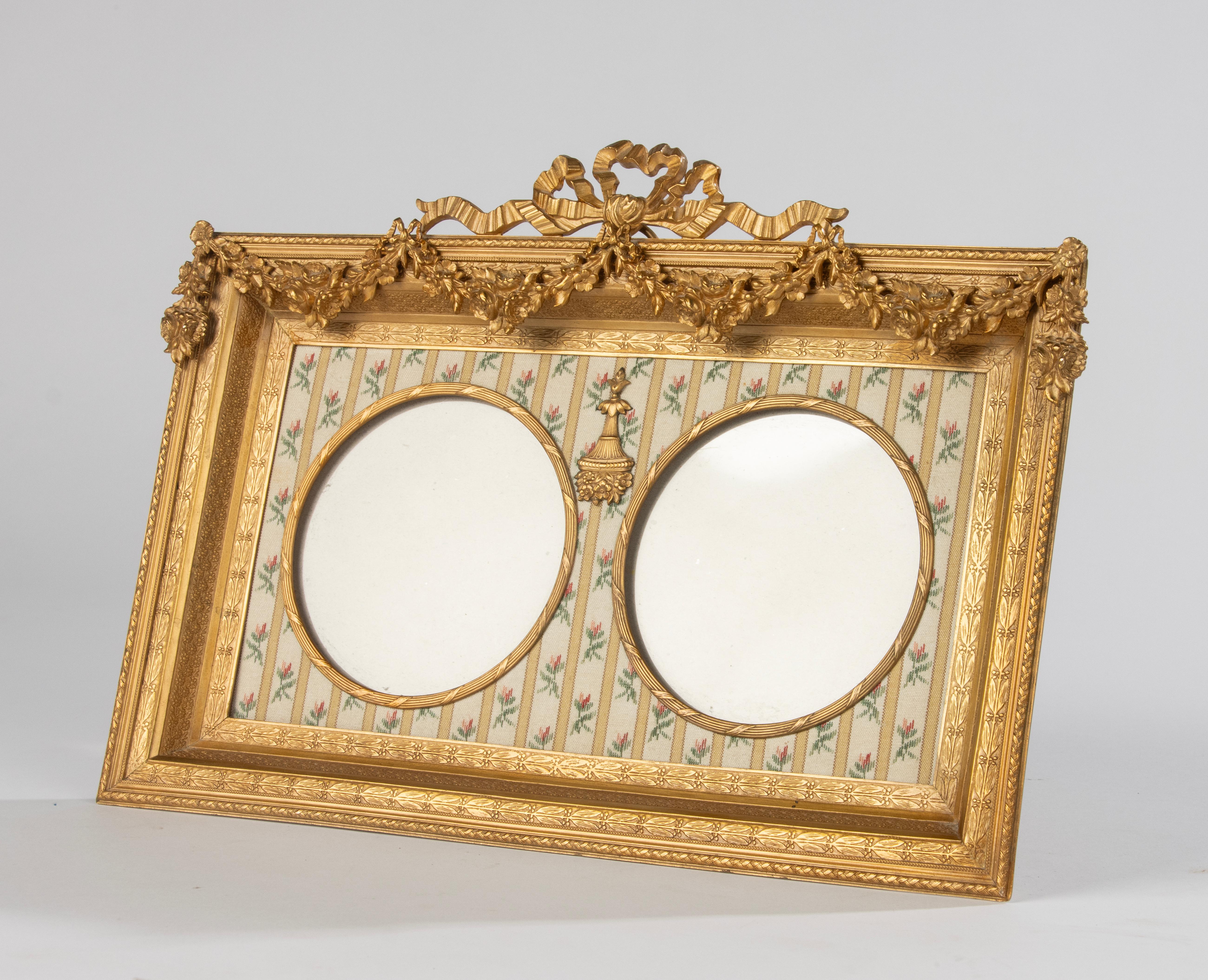 A refined bronze ormolu gilt picture frame in Louis XVI style. Ornate with flower garlands, ribbons and bows. 
Thew picture frame is in very good condition. Beautiful colour and very fine craftsmanship. 
Dimensions frame: 23 cm tall and 31 cm wide.