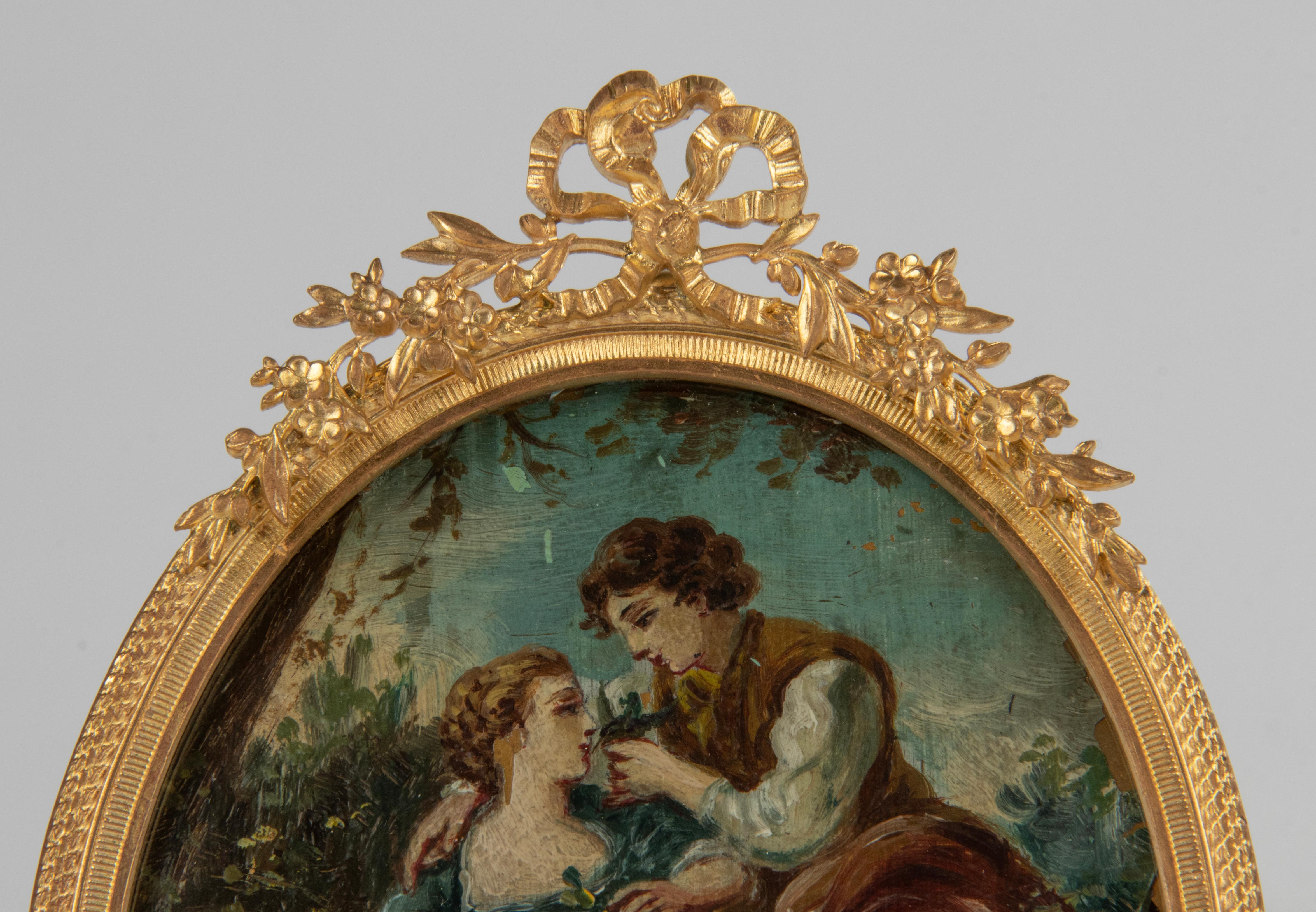A refined picture frame made of bronze and brass, with a gilt ormolu patina. On top a ribbon and bow, flanked by flower scrolls. Inside an antique romantic oil painting. But it can be used as a picture frame, standing or on the wall.
Made in