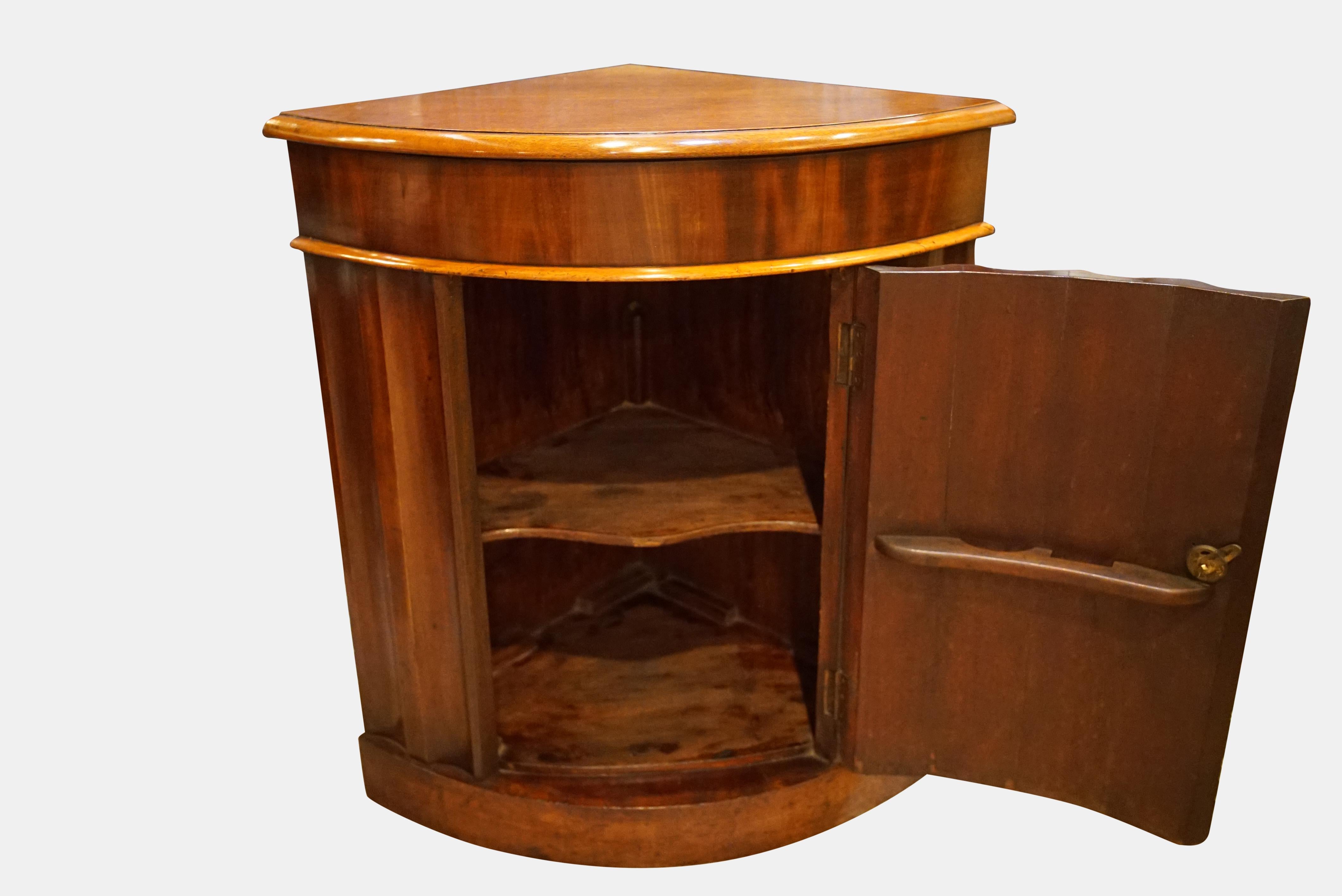 A mid-19th century mahogany corner cupboard with shaped front (top re-polished),

circa 1860.