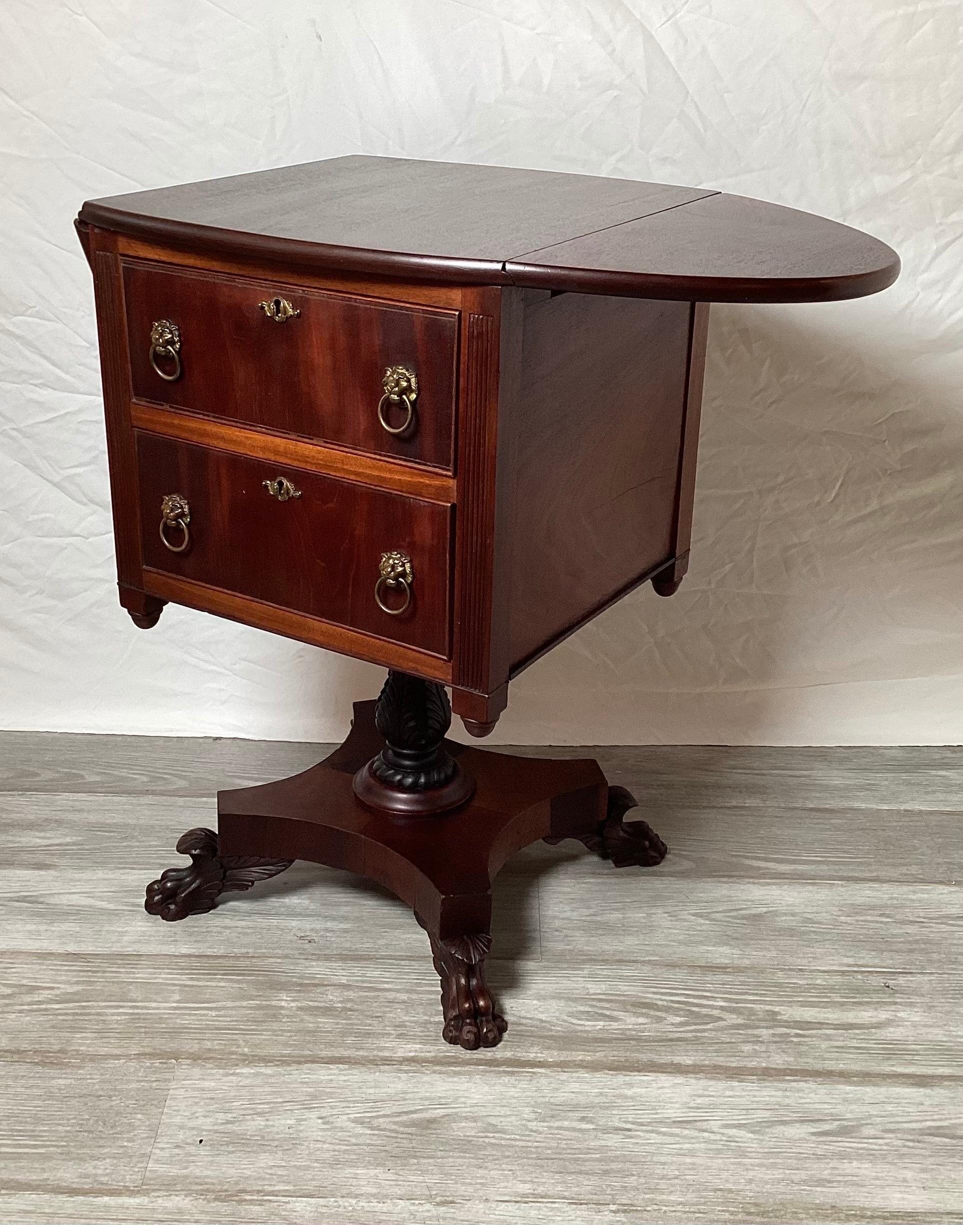 A mid 19th Century Honduran Mahogany two drawered working table with hand circle drop leaves. The box form on beautifully hand carved column and footed plinth base.