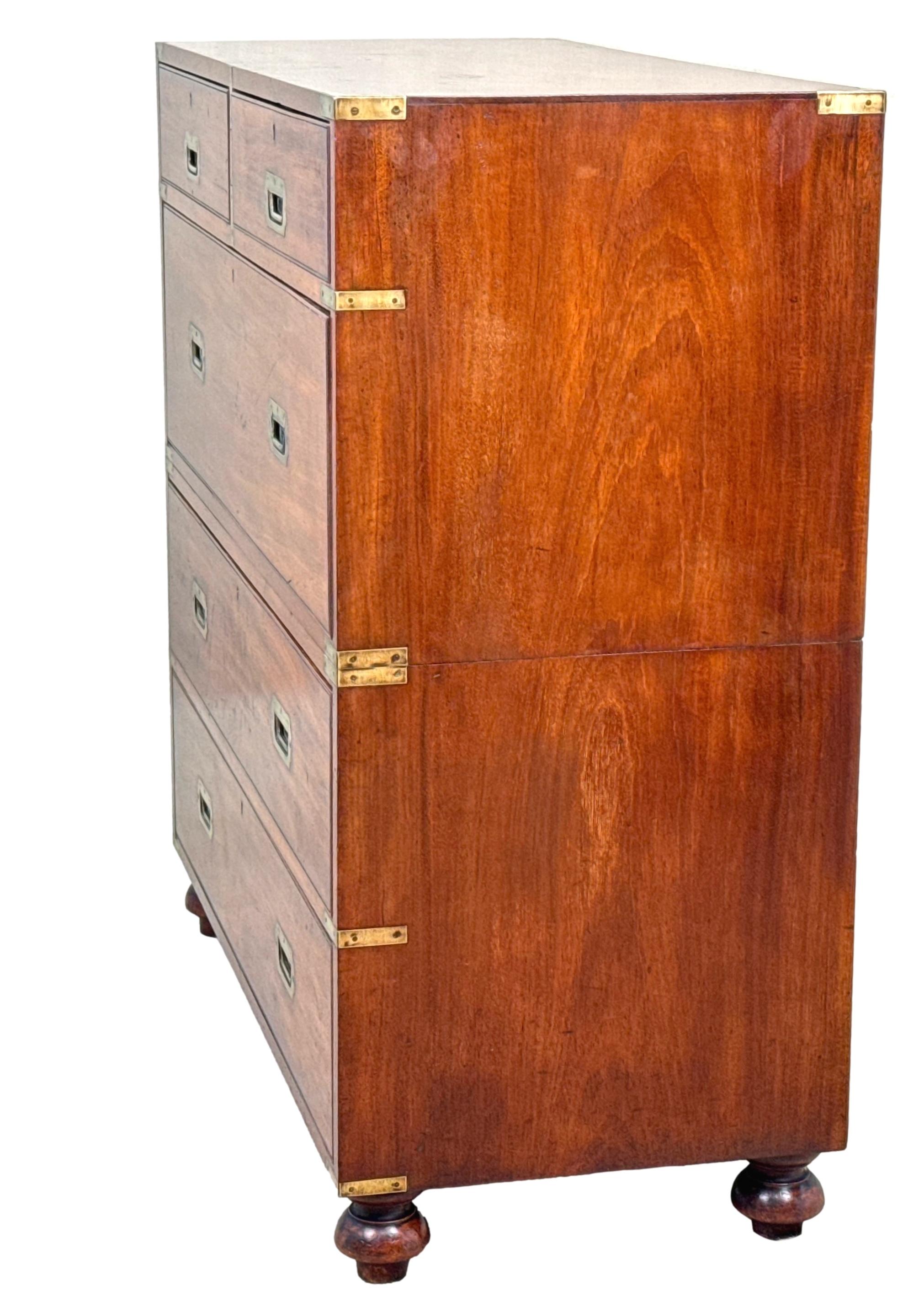 A Very Good Quality Mid 19th Century Mahogany Military Campaign Chest In Two Parts, With Original Brass Bound Decoration And Original Flush Fitted Brass Handles To Five Drawers, Raised On Original Turned Feet.

As the name suggests, Military