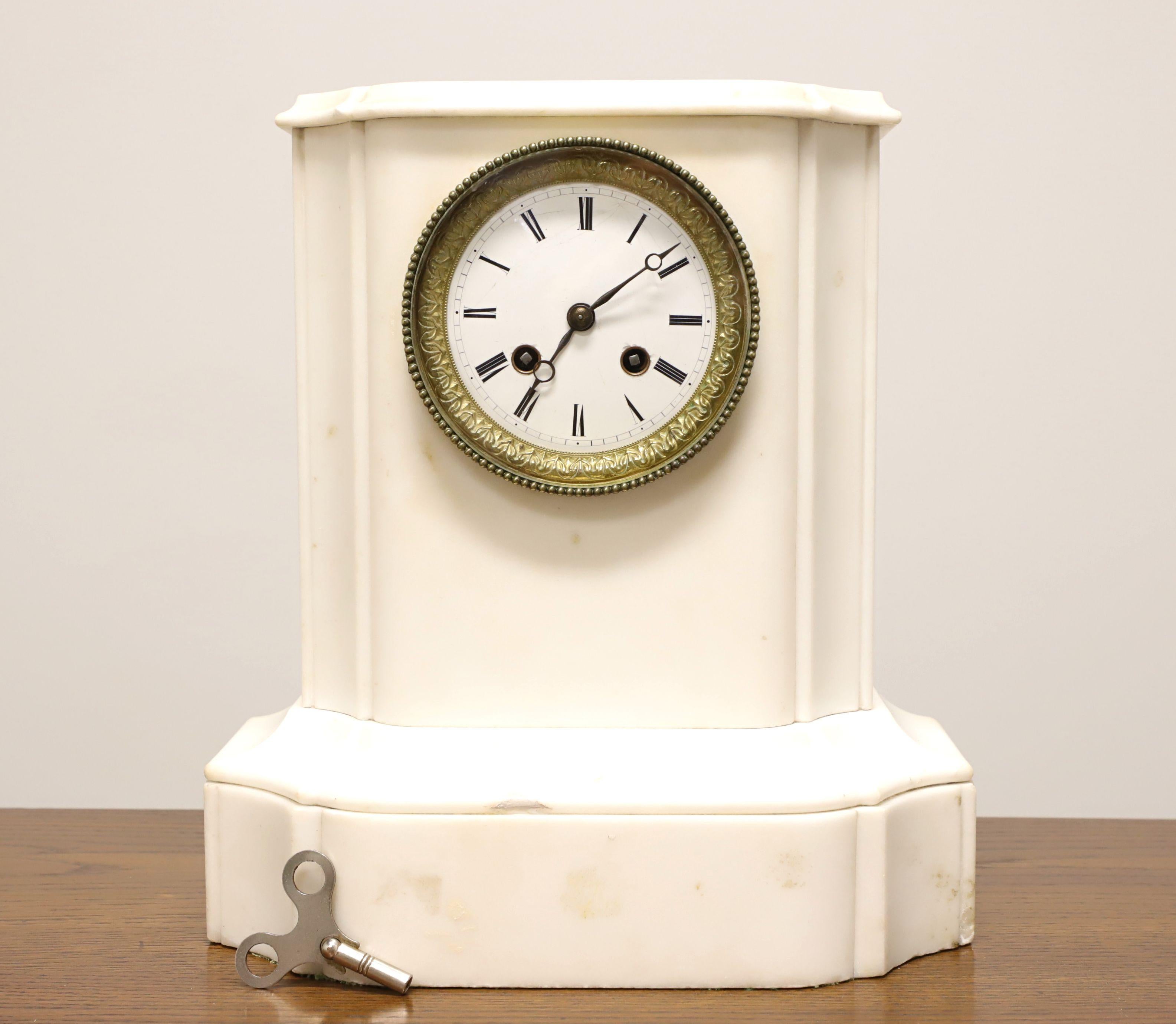 An antique Empire style marble chime mantel clock, unbranded. White marble encasing the clock works. Round decorative brass encased glass covered clock face has Roman numbers marking the hours, dash for minutes, hour and minute hands. Opens for