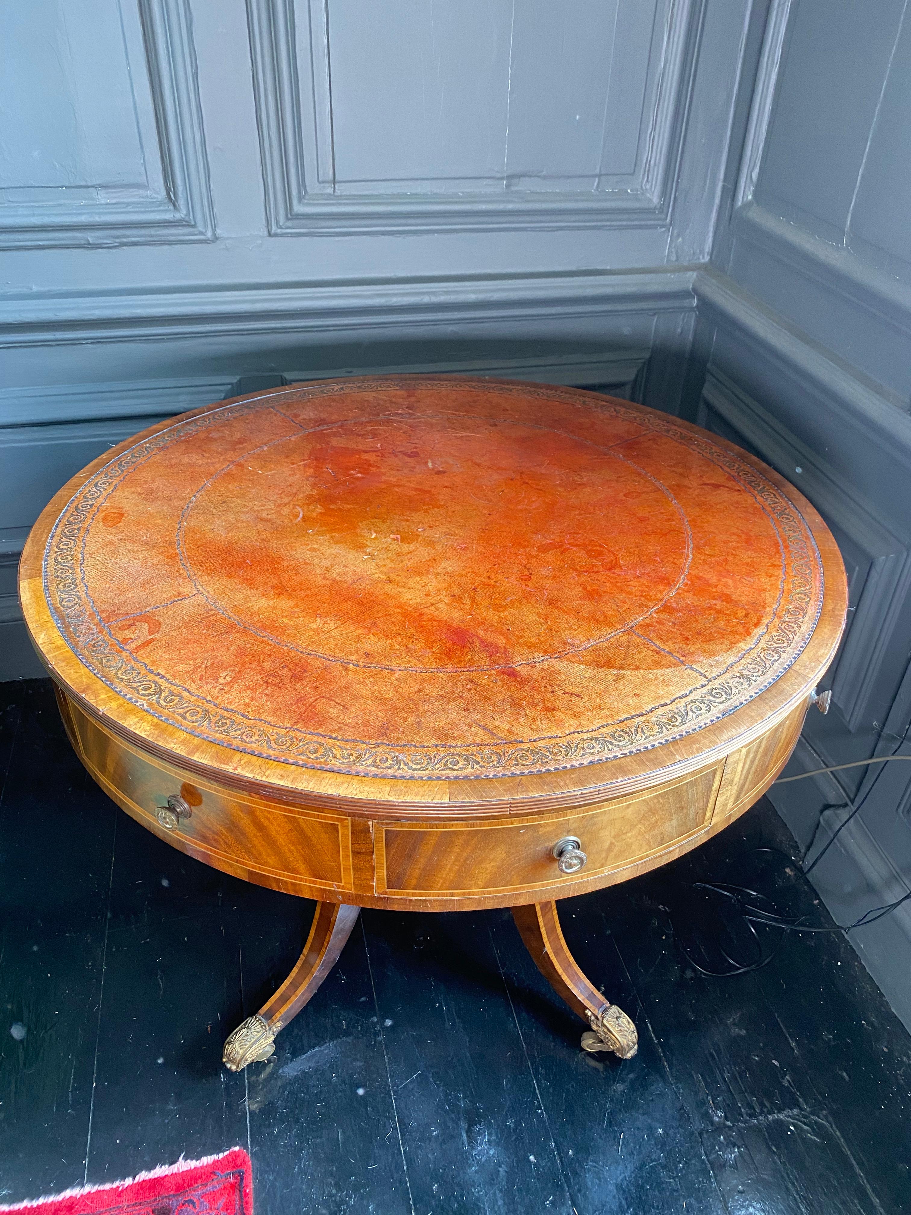 This is an exquisite mahogany and marquetry drum table.

With and there are four useful drawers in the frieze.

The table is supported with a single central stem of walnut standing on three reeded splayed legs that terminate in brass lion's paw