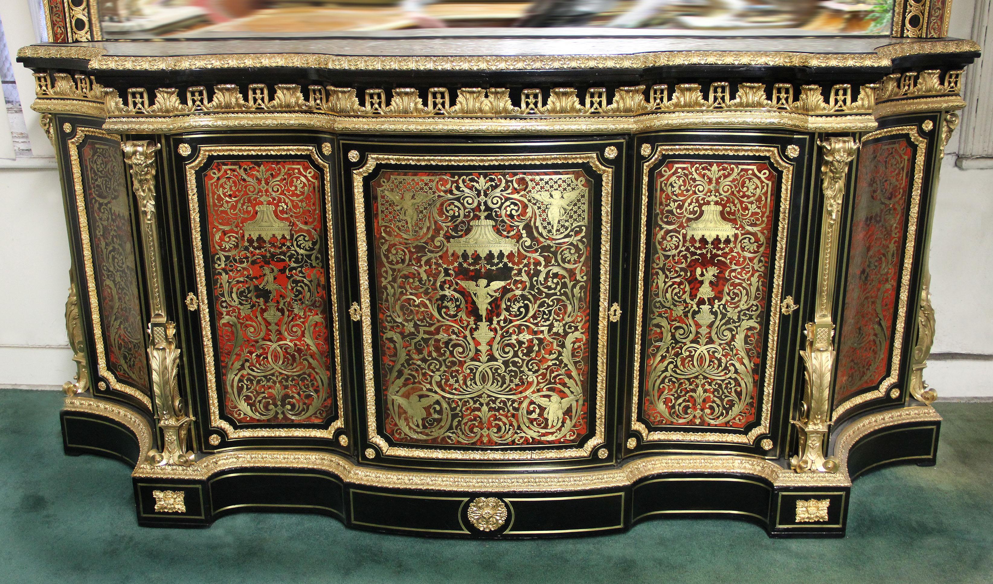 A mid-late 19th century monumental Napoleon III gilt bronze mounted ebony, red tortoiseshell and designed brass Boulle style cabinet and mirror

Each Boulle style marquetry panel with designs in the manner of Jean Bérain, the cabinet surmounted by