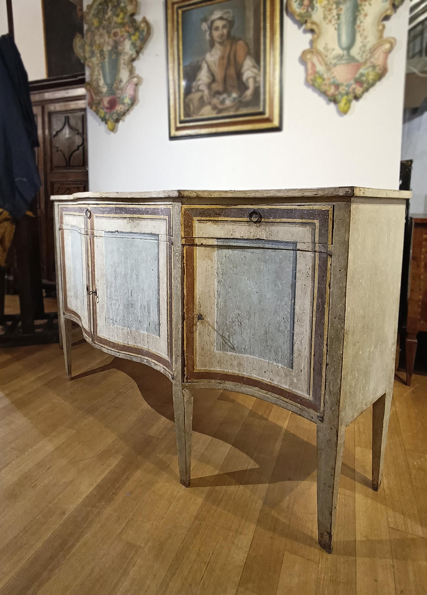 Refined carved wooden sideboard painted in tempera, with contemporary painting. The sideboard features truncated pyramid legs and a curved front, lending it a unique look. The painted decorations on the front and top, in brown, white, yellow, and