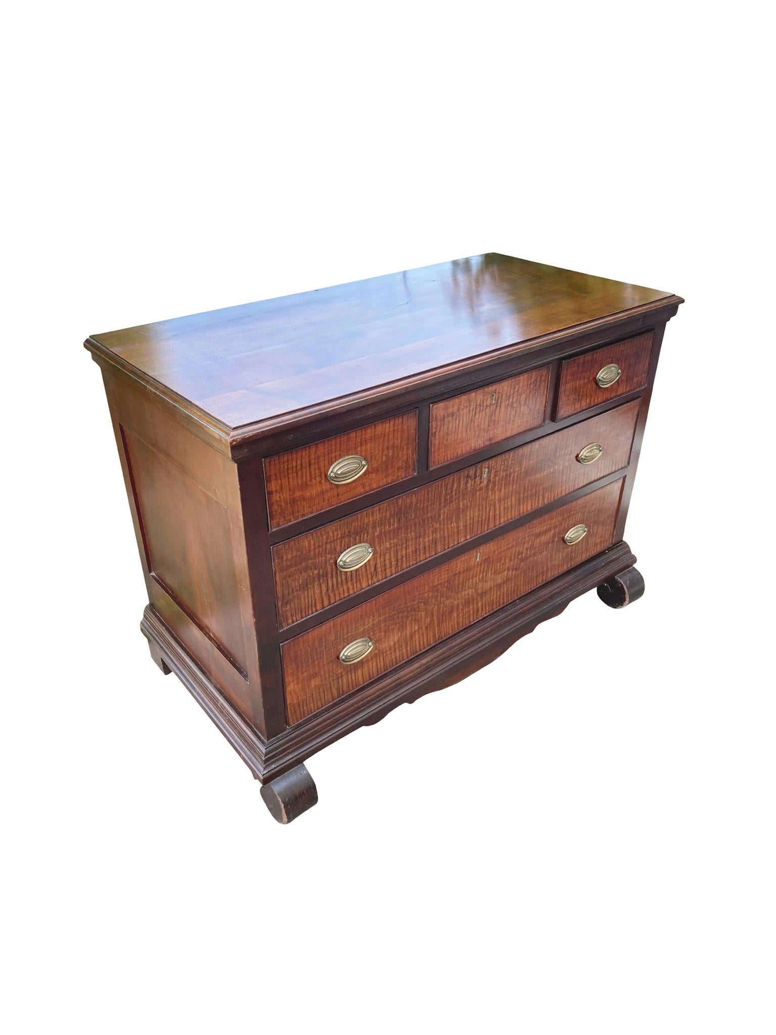 We love the organic and warm features of this American Classical bureau. Hand-crafted in the mid-19th century, it's comprised of mahogany with tiger maple fronts. There are three small top drawers and two full length bottom drawers. The brass pulls