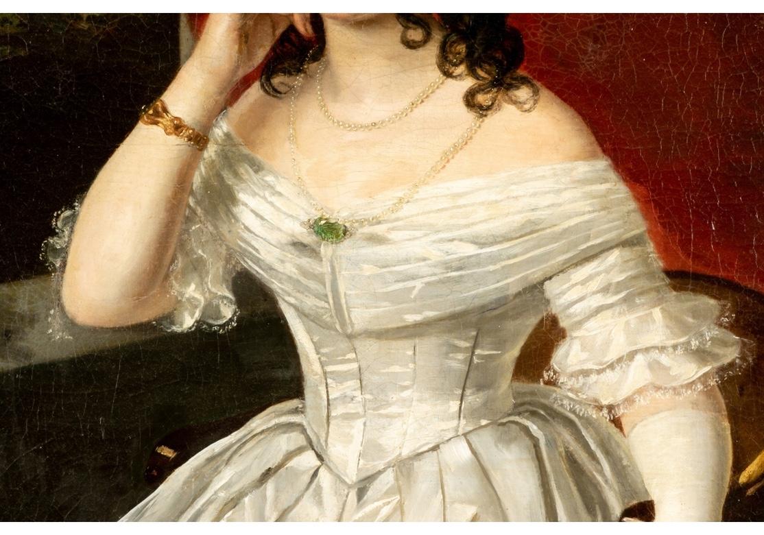 Mid-19th century oil on canvas. A portrait depicting a young seated woman wearing an off the shoulder white gown and her neck garnished with an elaborate pearl and emerald necklace. One gloved hand rests over the armrest of her chair while the other