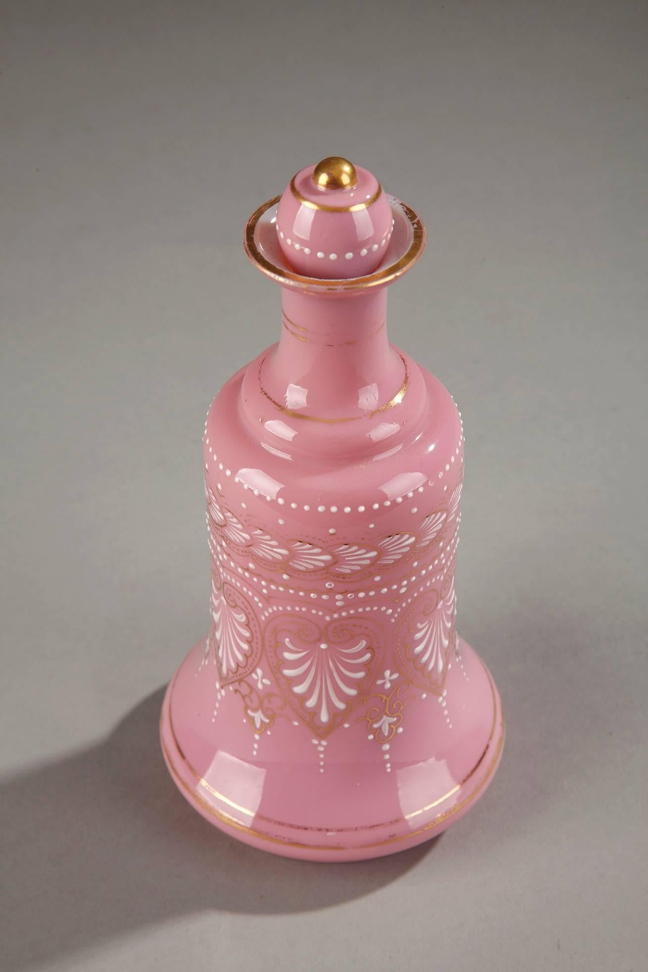 Pink opaline flask with white enamel decorations featuring palmettes, small dots, and floral motifs. Gold bands accent the base and the neck. The opaline imitates porcelain and is embellished with motifs from the Napoleonic Empire’s decorative