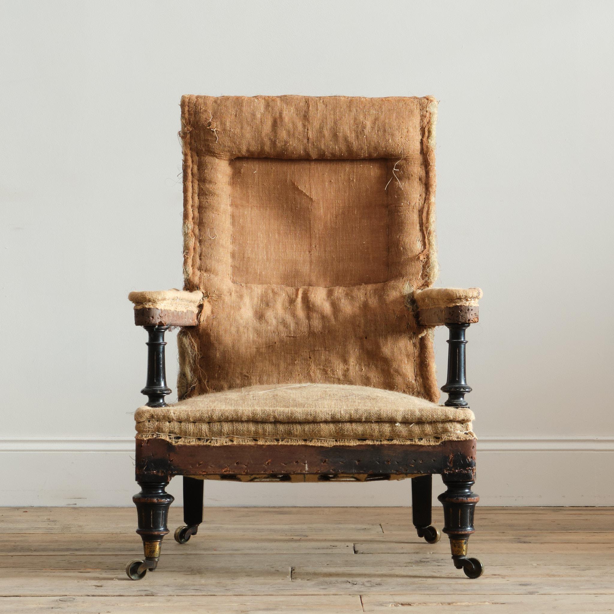 Sillón abierto de casa de campo de mediados del siglo XIX. Levantada sobre patas delanteras y apoyabrazos de nogal ebonizado torneado y tallado. Las patas traseras ensanchadas y achaflanadas y todas las patas con las ruedas originales. C1860 y casi