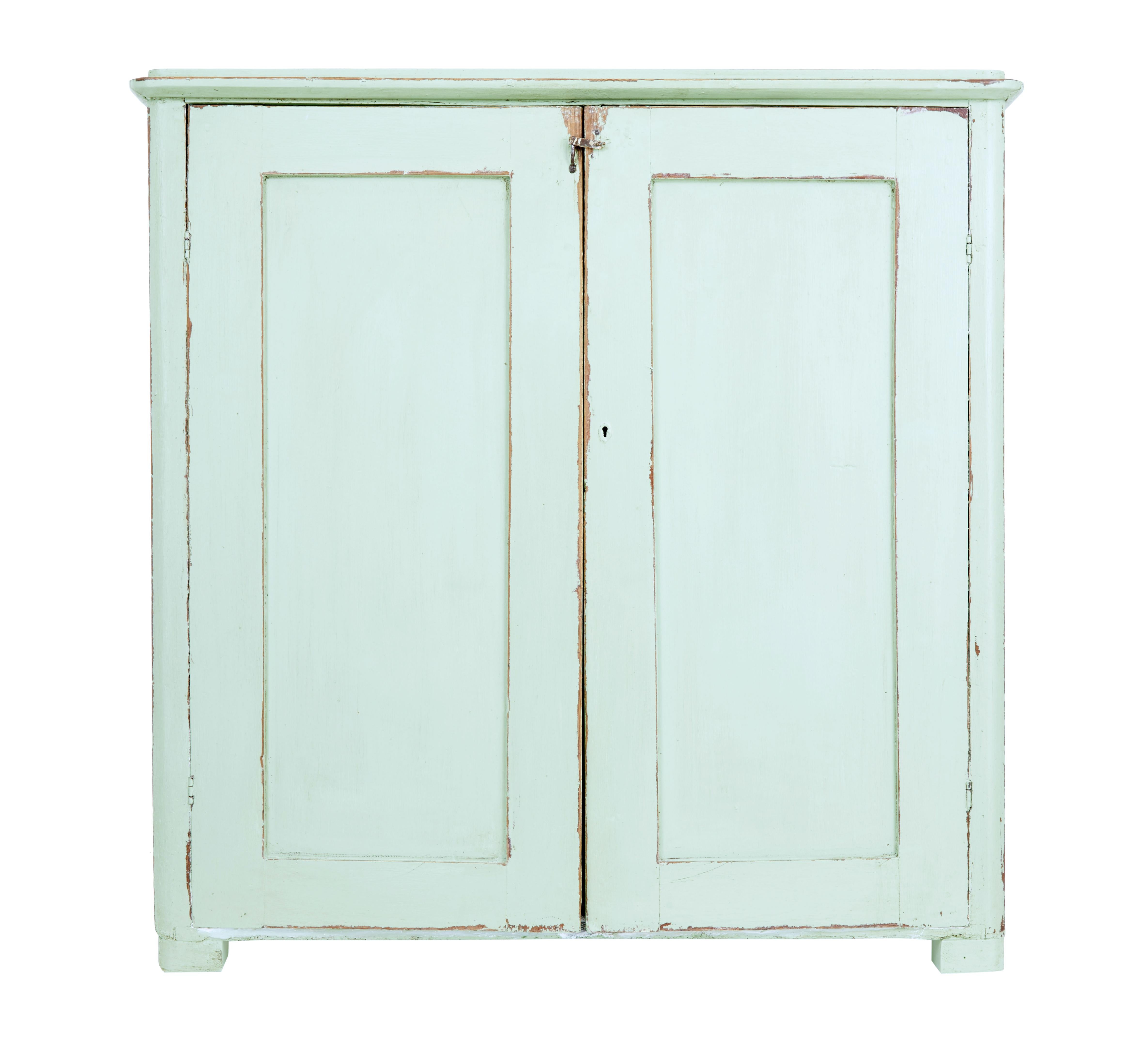 Rustic Swedish kitchen cupboard, circa 1850.

Traditional pine double door cupboard which opens to 4 shelves which have been painted white. There is also a loose fitting drawer.

Later paint and surface marks, losses to the bottom of 1 side