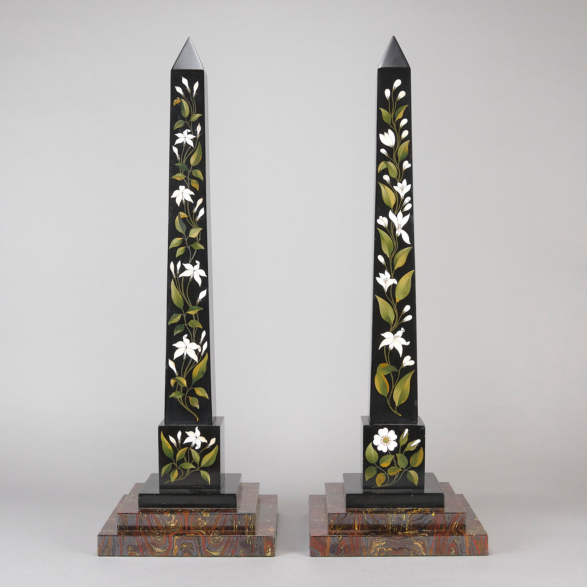 Excellente paire d'obélisques en marbre noir d'Ashford datant du milieu du XIXe siècle, incrustés d'une sélection de spécimens de marbres appliqués à l'avant de chaque colonne de manière décorative et florale, et reposant sur des pieds étalés à