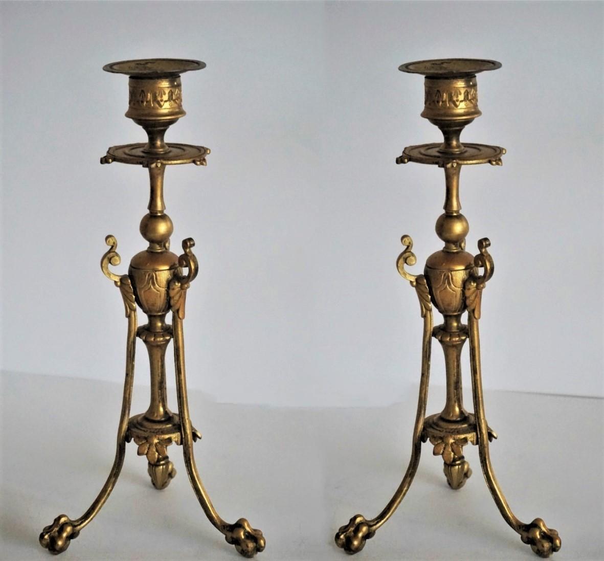 Coppia di candelieri in bronzo dorato stile Impero sollevati su tre zampe di leone, Francia, metà del XIX secolo.
 