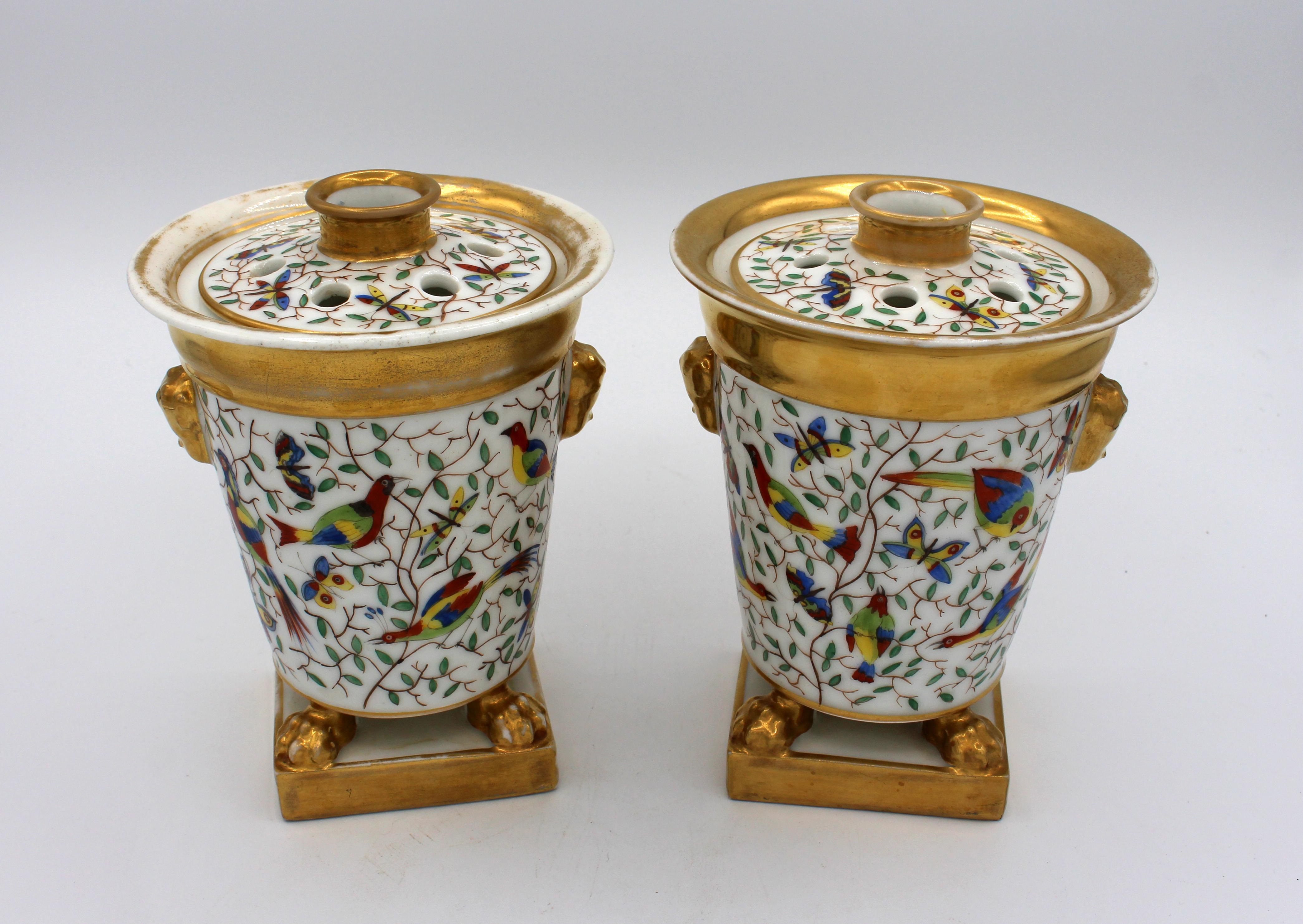 A mid-19th century pair of bough pots (often called potpourri urns). French. Old Paris porcelain. Trailing vines filled with colorful birds and butterflies. Burnished gold lion masks, feet, and bandings. One inner rime of cover has a loss. Unmarked.