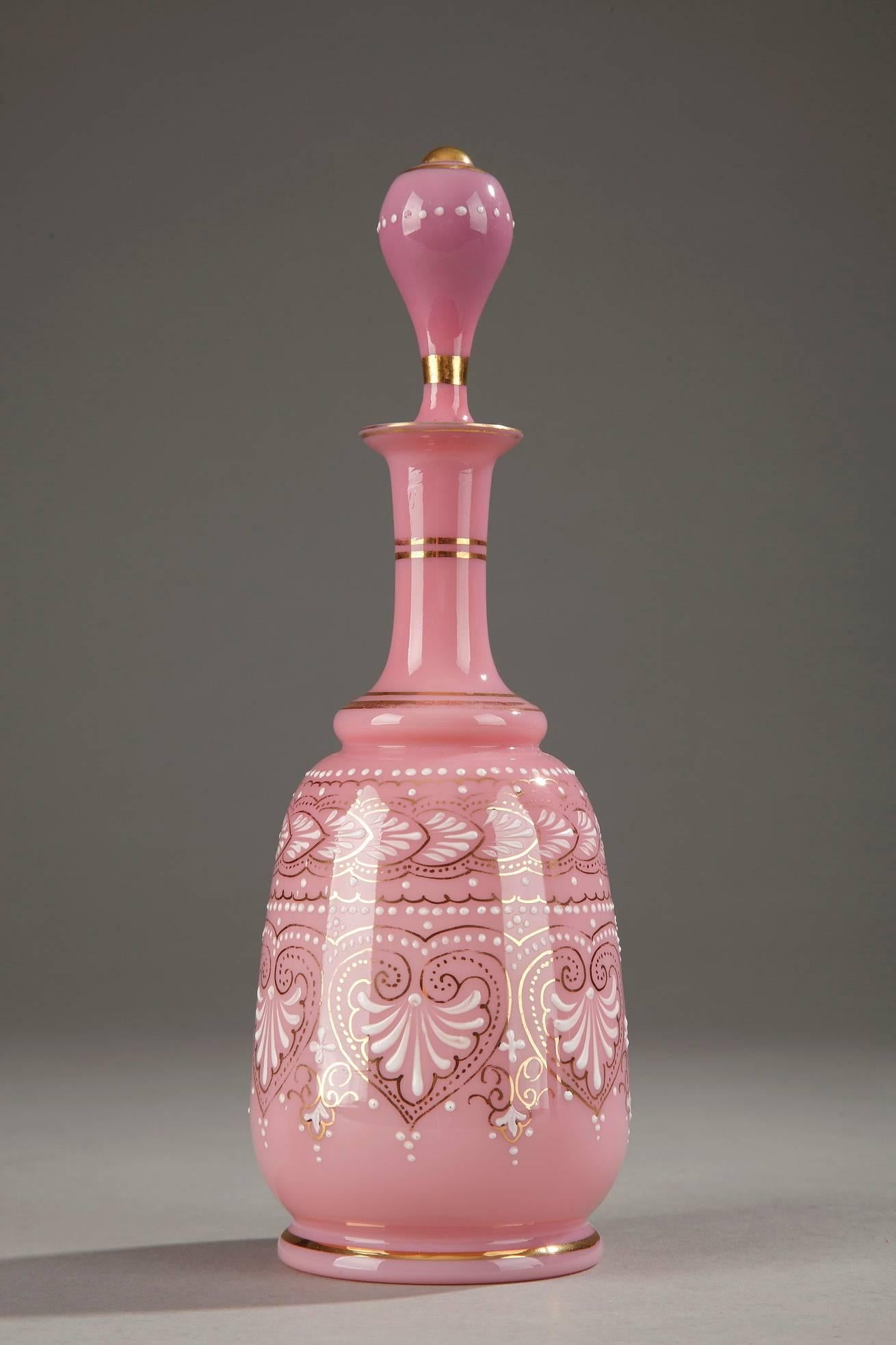 Pink opaline flask decorated in white enamel with palmettes, small dots and floral motifs. Gold bands accent the base and the neck. The stopper is topped with a ball. Very delicate enamel work. Probably baccarat,

circa 1850.

Dimensions: L 3