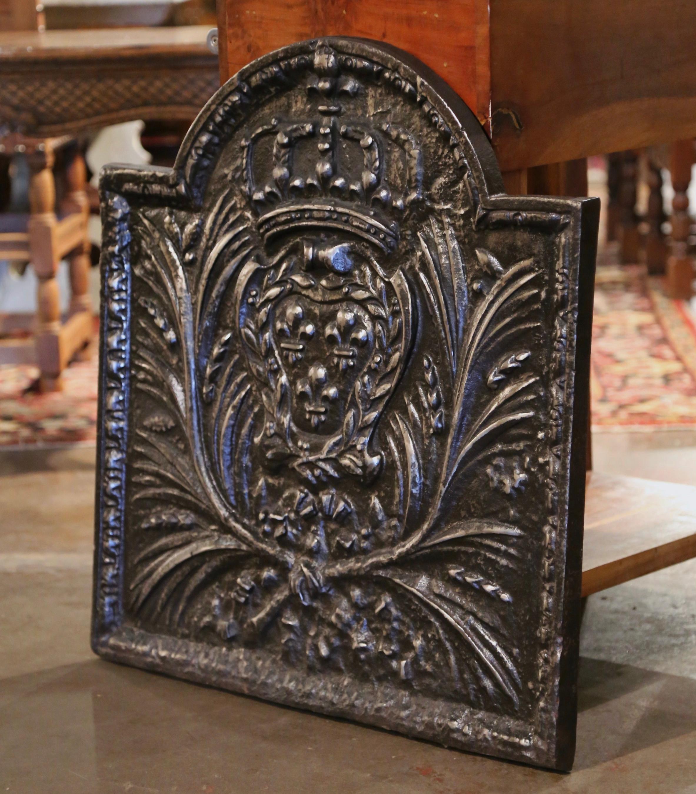 Decorate your fireplace or kitchen back splash with this elegant antique fire back. Crafted in France circa 1850 and almost square in shape, the ornate arched fireplace essential features a center medallion with the Royal Arms of France after