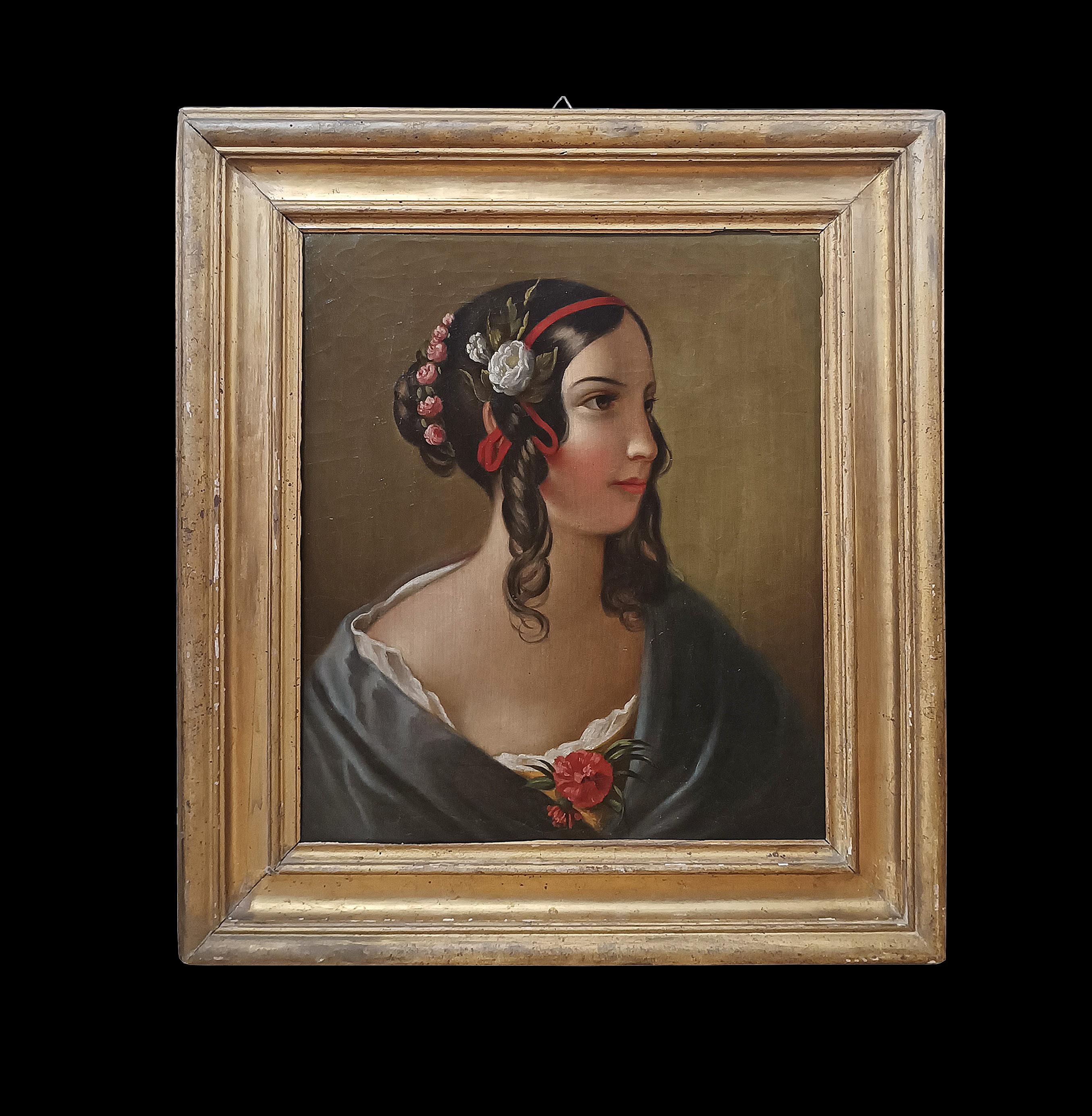 Precioso cuadro de tamaño modesto, realizado en óleo sobre lienzo y enmarcado en un bastidor de madera tallada y dorada. El cuadro representa el retrato de una joven con el pelo recogido y hermosos rizos en la parte delantera, adornado con un