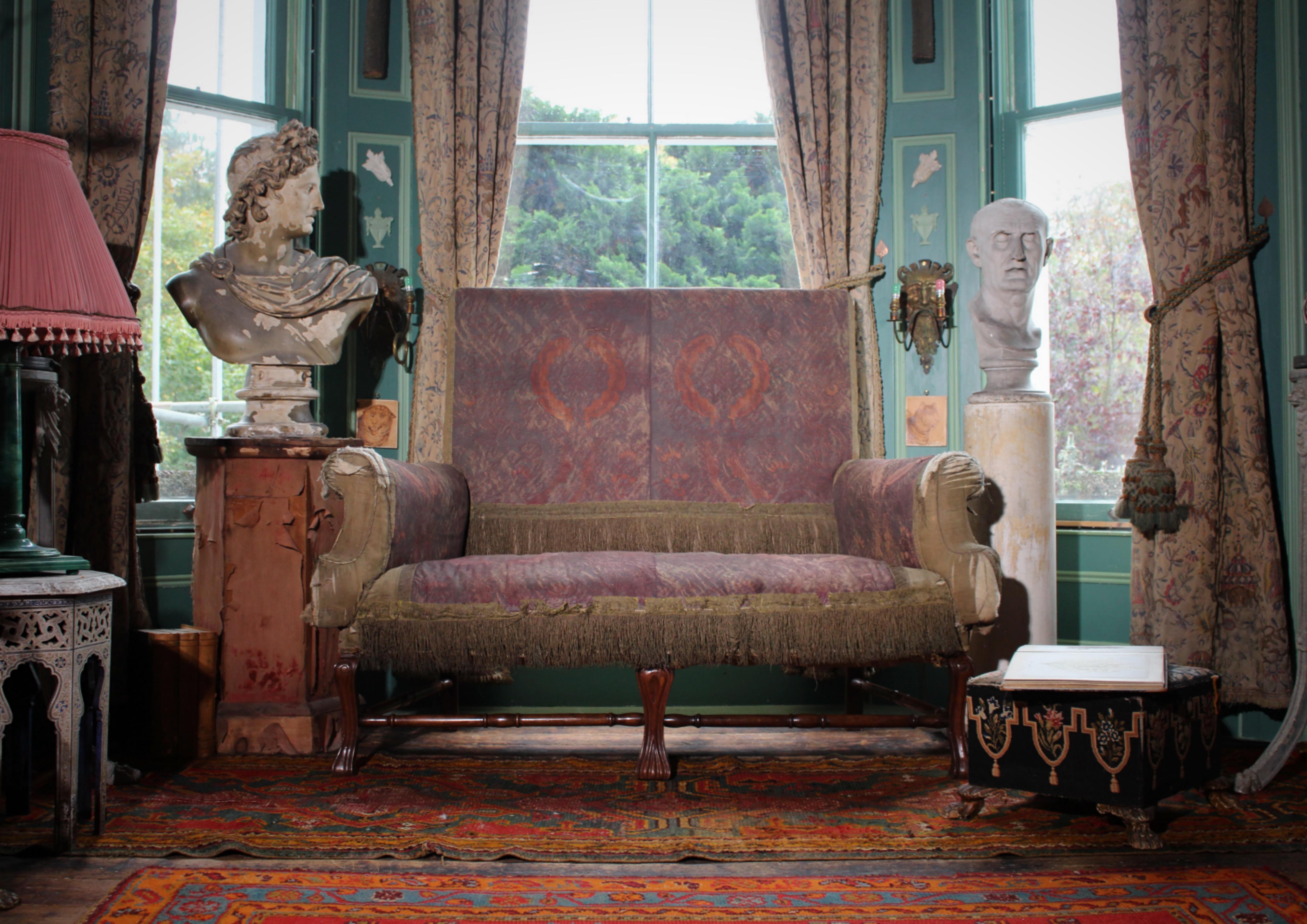 The most perfectly faded mid 19th century, country house Queen Anne revival lovers settee.

Upholsted in an unusual muted pink and purple batik wax resist fabric, with metallic fringing on carved cabriole legs united by connecting turned