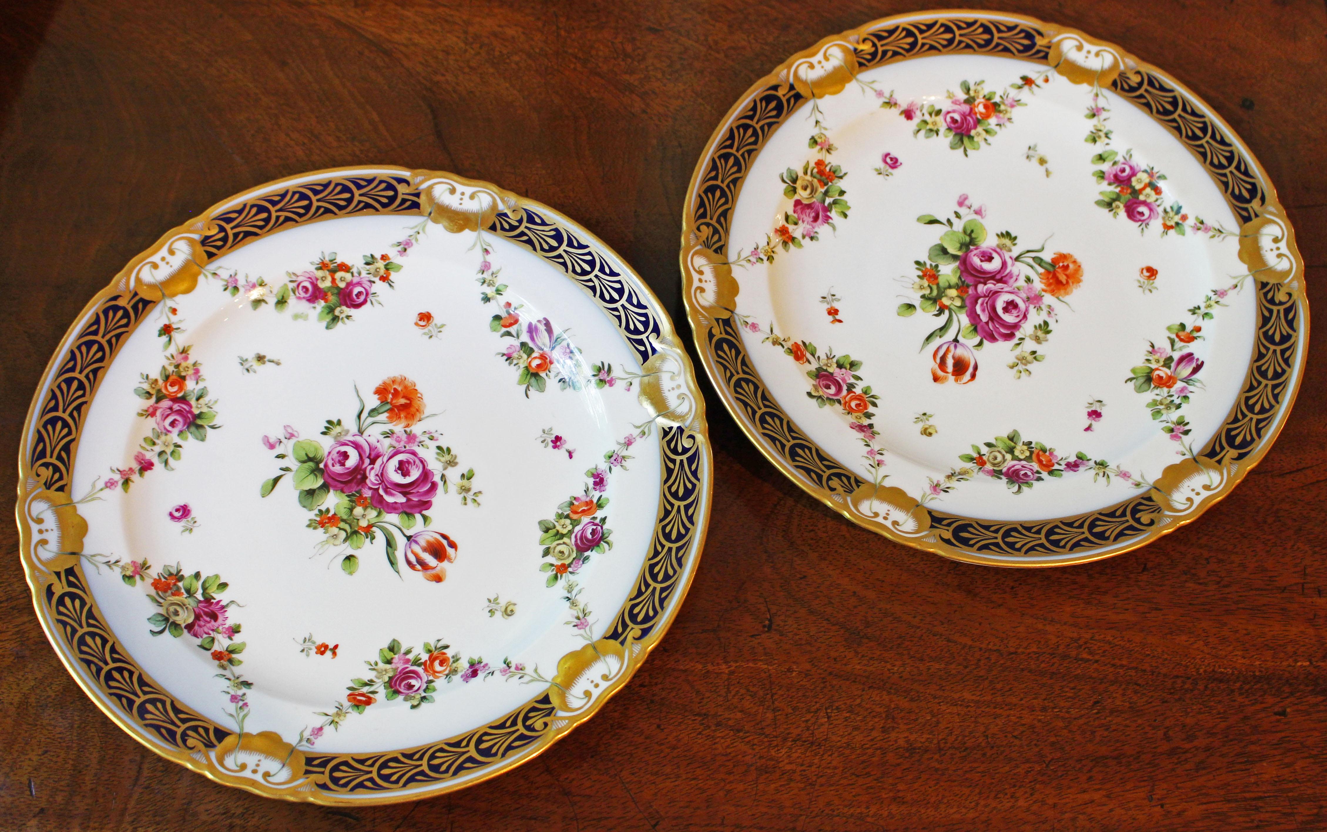 An exquisitely painted pair of cabinet plates, mid 19th century, Royal Vienna, banded in cobalt and gilt and swagged in Neo-classical taste with floral festoons. Floral central reserve. 10