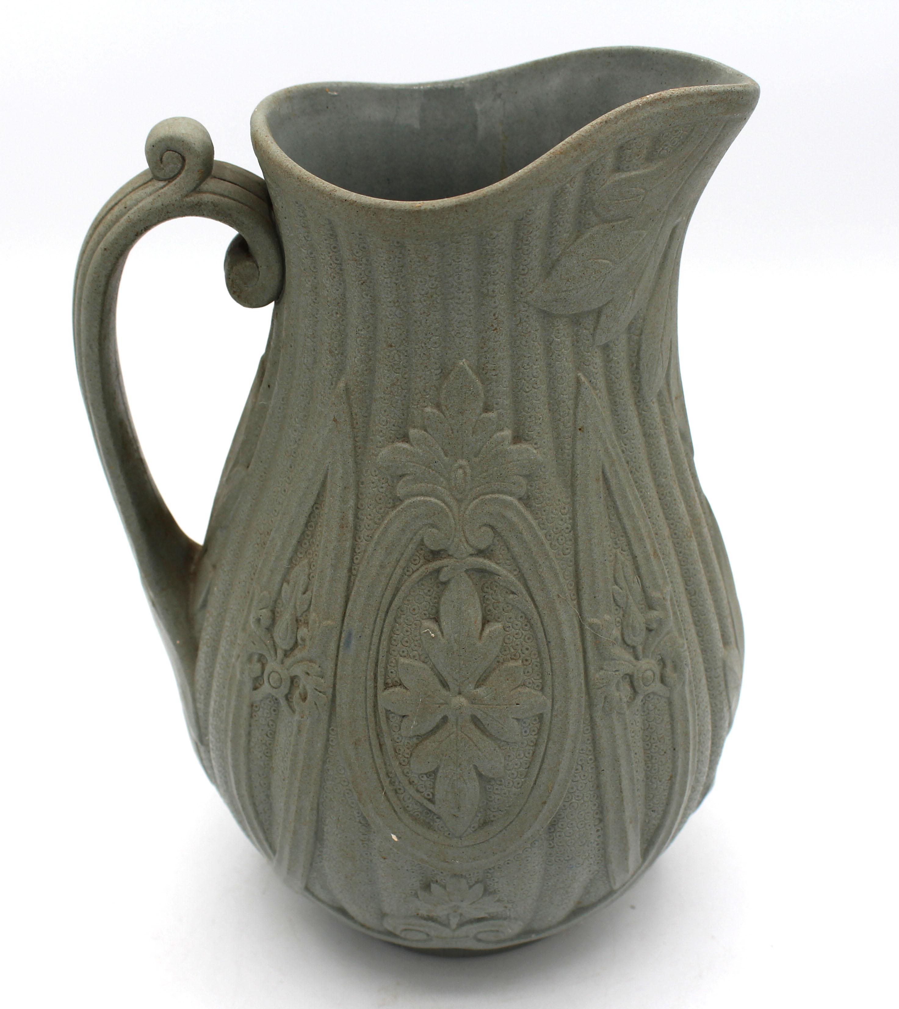 Mid-19th century salt glazed stoneware pitcher, English. Relief molded in soft green with neoclassical motifs. Known parian examples also unattributed. Marked: W, 12. Provenance: Estate of Katherine Reid, former Director of the Cleveland Museum of