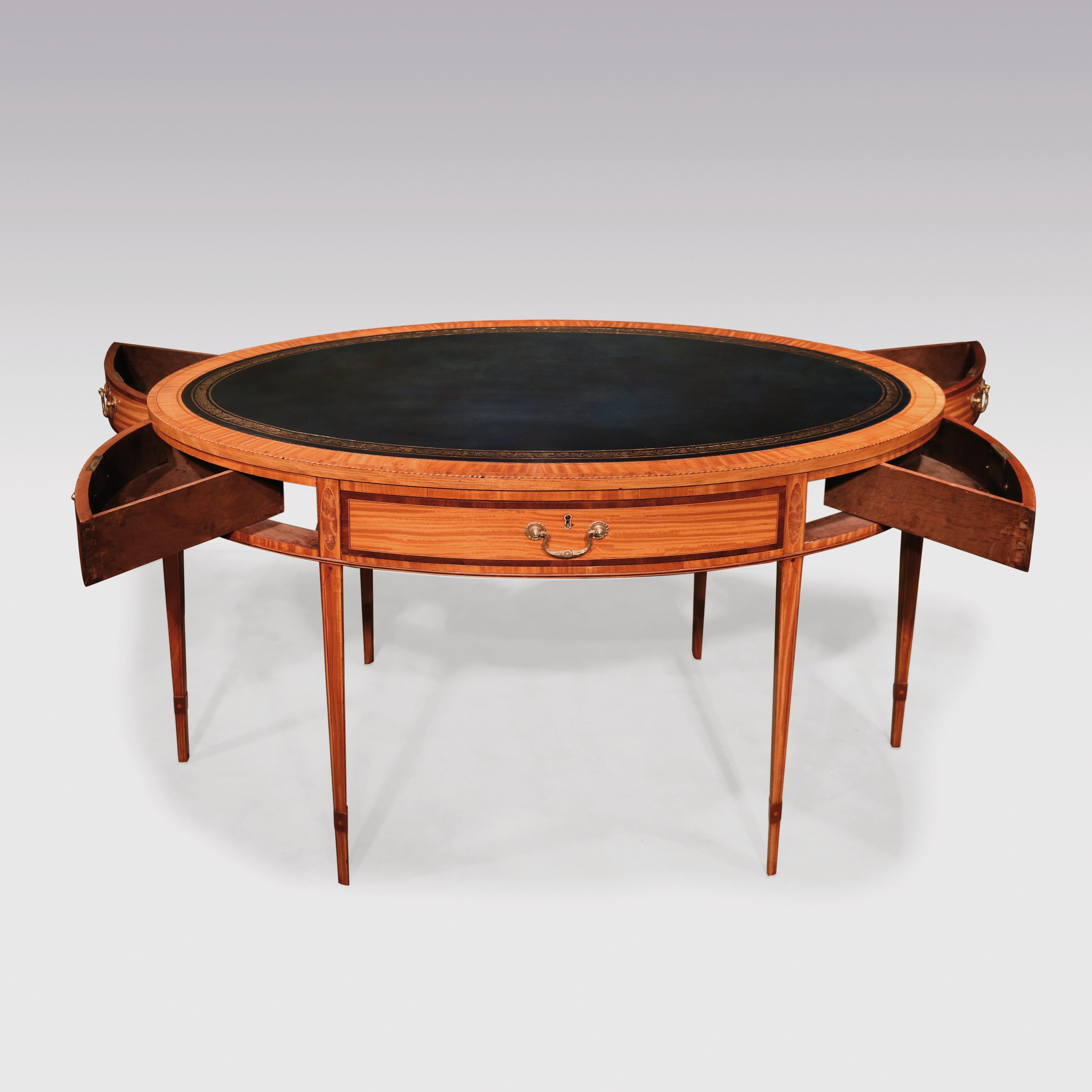 A fine mid-19th century satinwood oval writing table in the Sheraton manner, boxwood and ebony lined throughout, having tulipwood and satinwood cross-banded gilt tooled blue leather top above 6 opening purple heart cross-banded drawers divided by