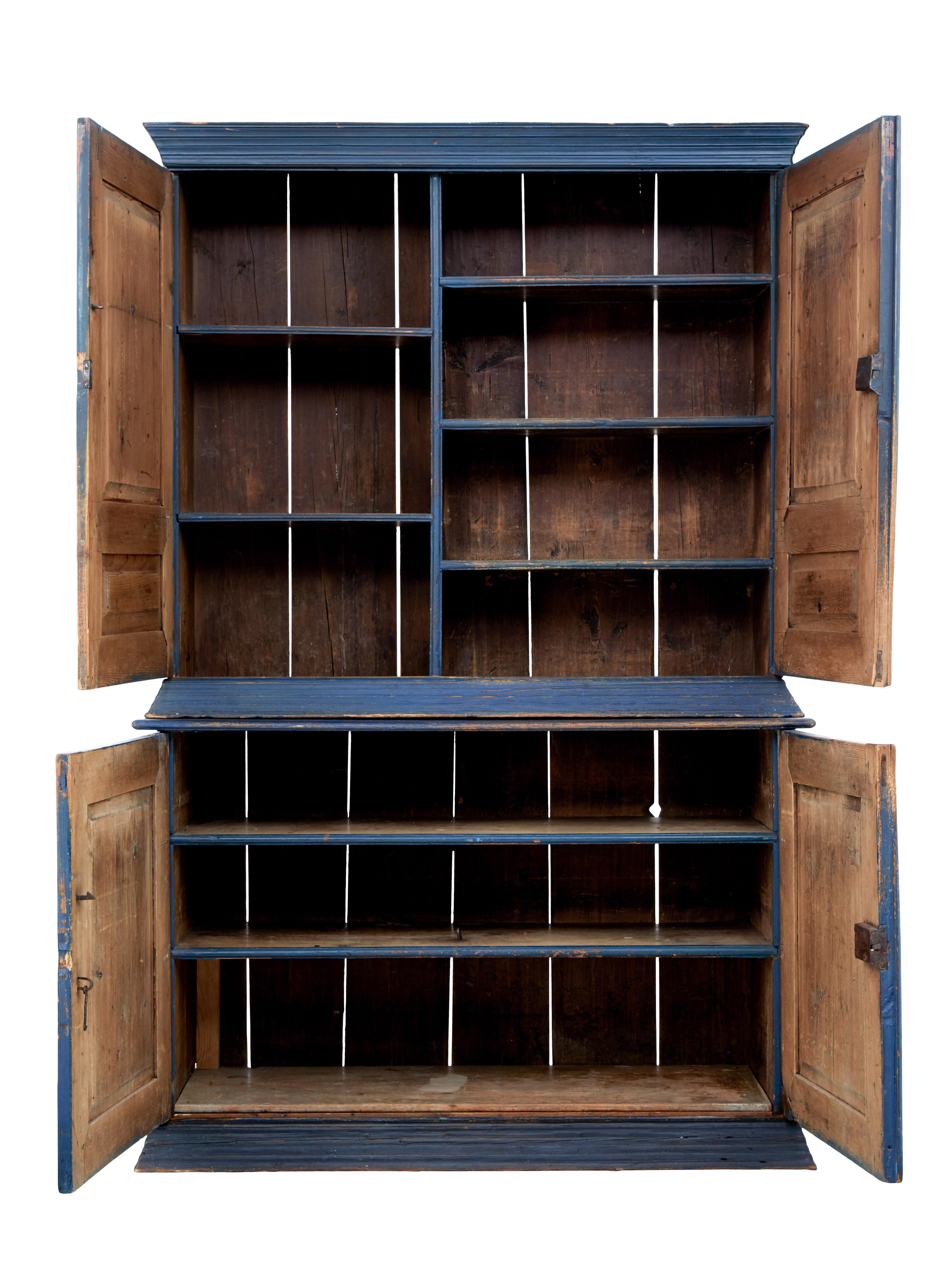 Mid-19th century Scandinavian painted housekeepers cupboard, circa 1860.

Large 2 part cupboard painted in original rustic blue. Top half with double doors that open to reveal an interior with a vertical partition and 5 fixed shelves. Bottom