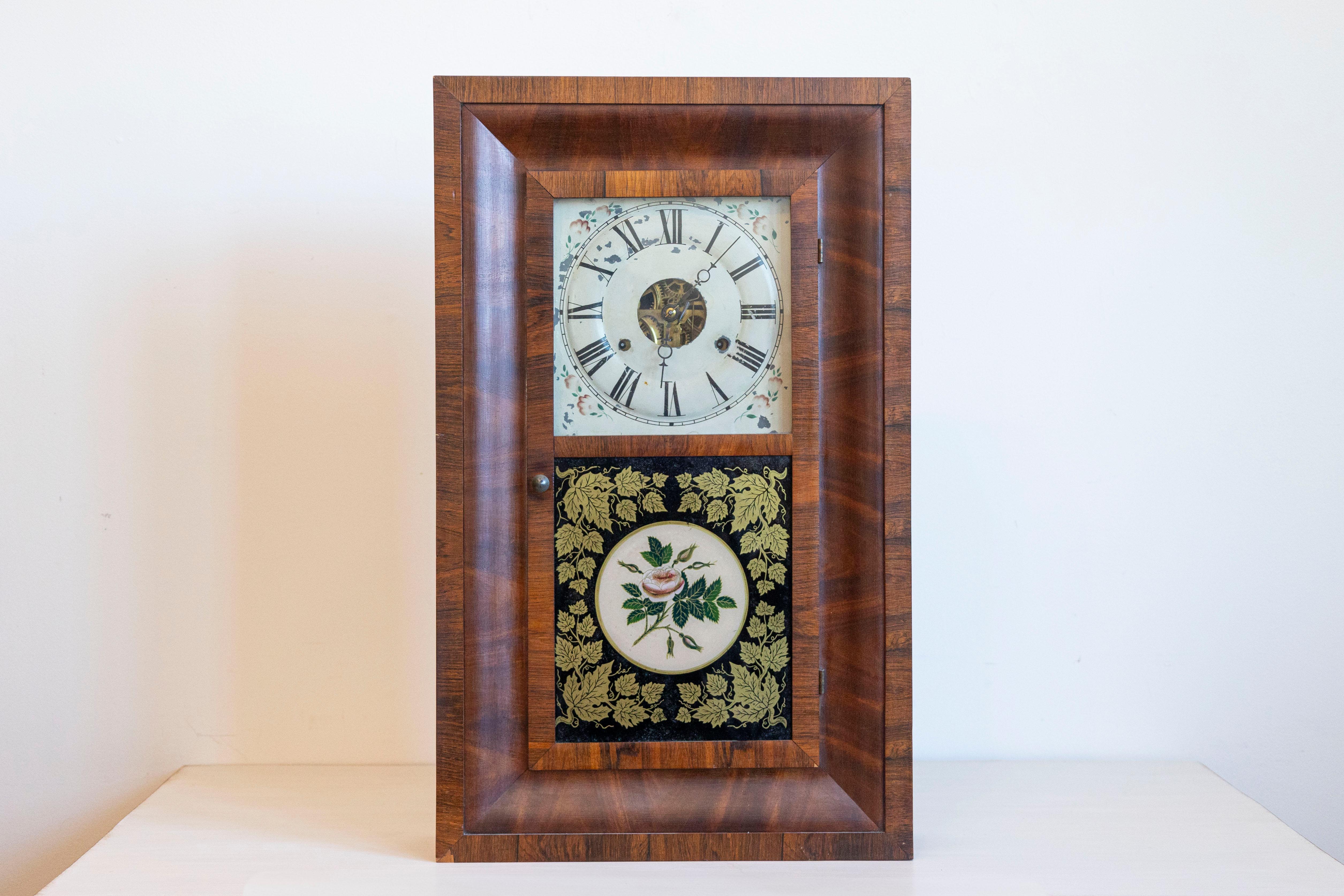 This exquisite mid-19th-century Seth Thomas Ogee shelf clock, crafted in Thomaston, Connecticut, showcases the refined craftsmanship of one of America’s most renowned clockmakers. The case features a rich mahogany veneer with classic ogee molding,