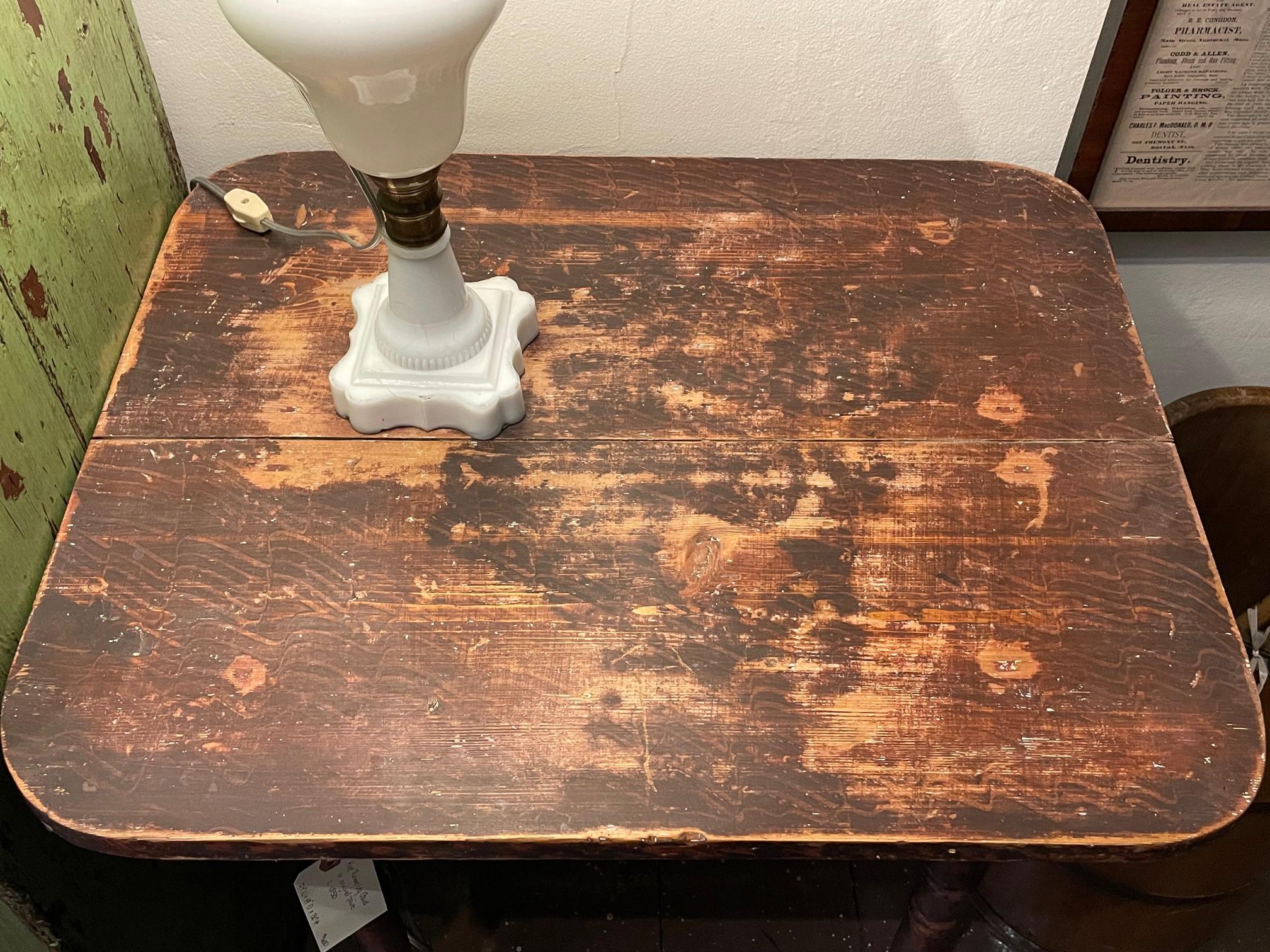 Diminutive mid 19th century Pine side table with two plank top over turned, tapering legs. With original decoratively applied brown over red paint in various patterns throughout. Table top surface wear consistent with age and use.