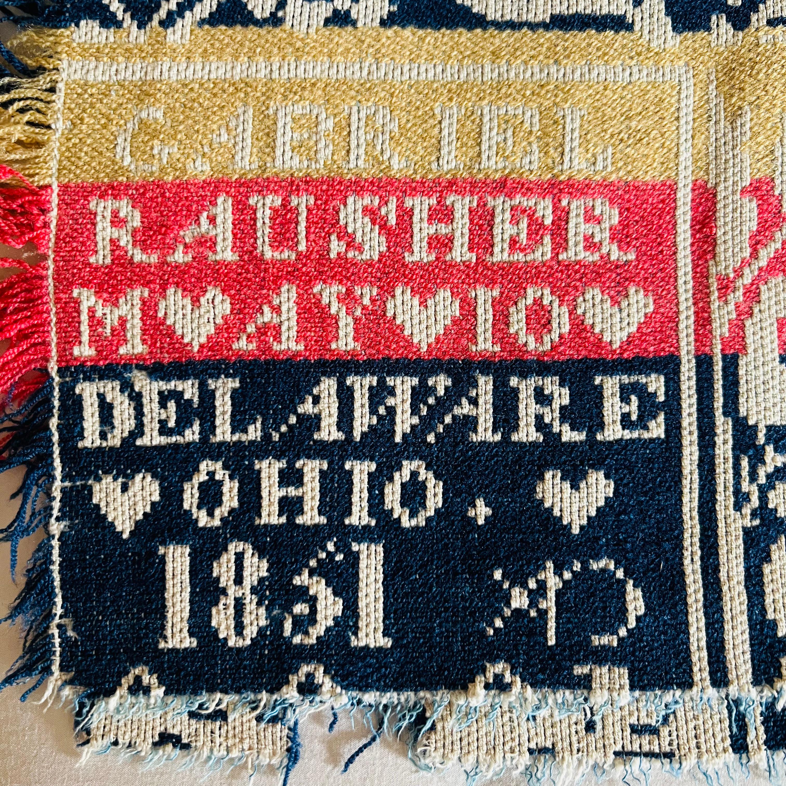 Ein geknüpftes Jacquard-Deckchen, handgewebt von Gabriel Rausher in Delaware, OH im Jahr 1851. Wolle und Baumwolle in leuchtendem Korallenrot, Gelb, zartem Creme und sattem Marineblau. Florales Medaillonmuster mit Vogeldetails.

Auf einem schmalen