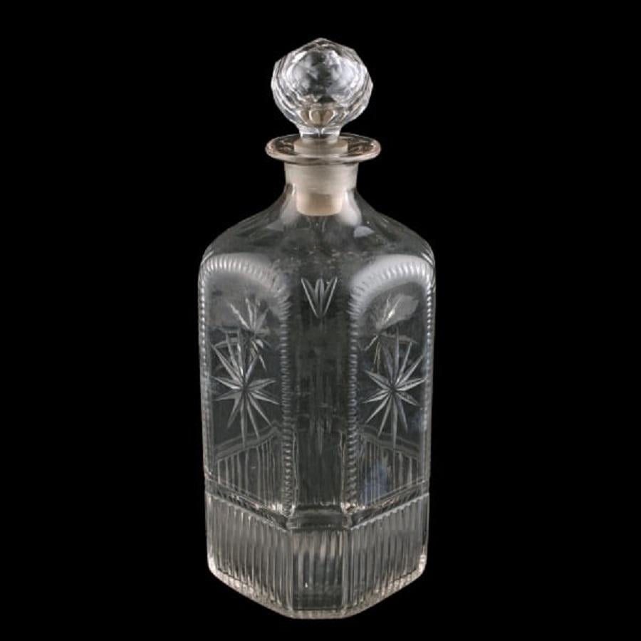 A middle of the 19th century cut glass spirit decanter and stopper.

The decanter is square in shape with chamfered corners and sloping shoulders.

The body of the decanter is decorated with cut stars and ribbing and the shoulders with oval cut