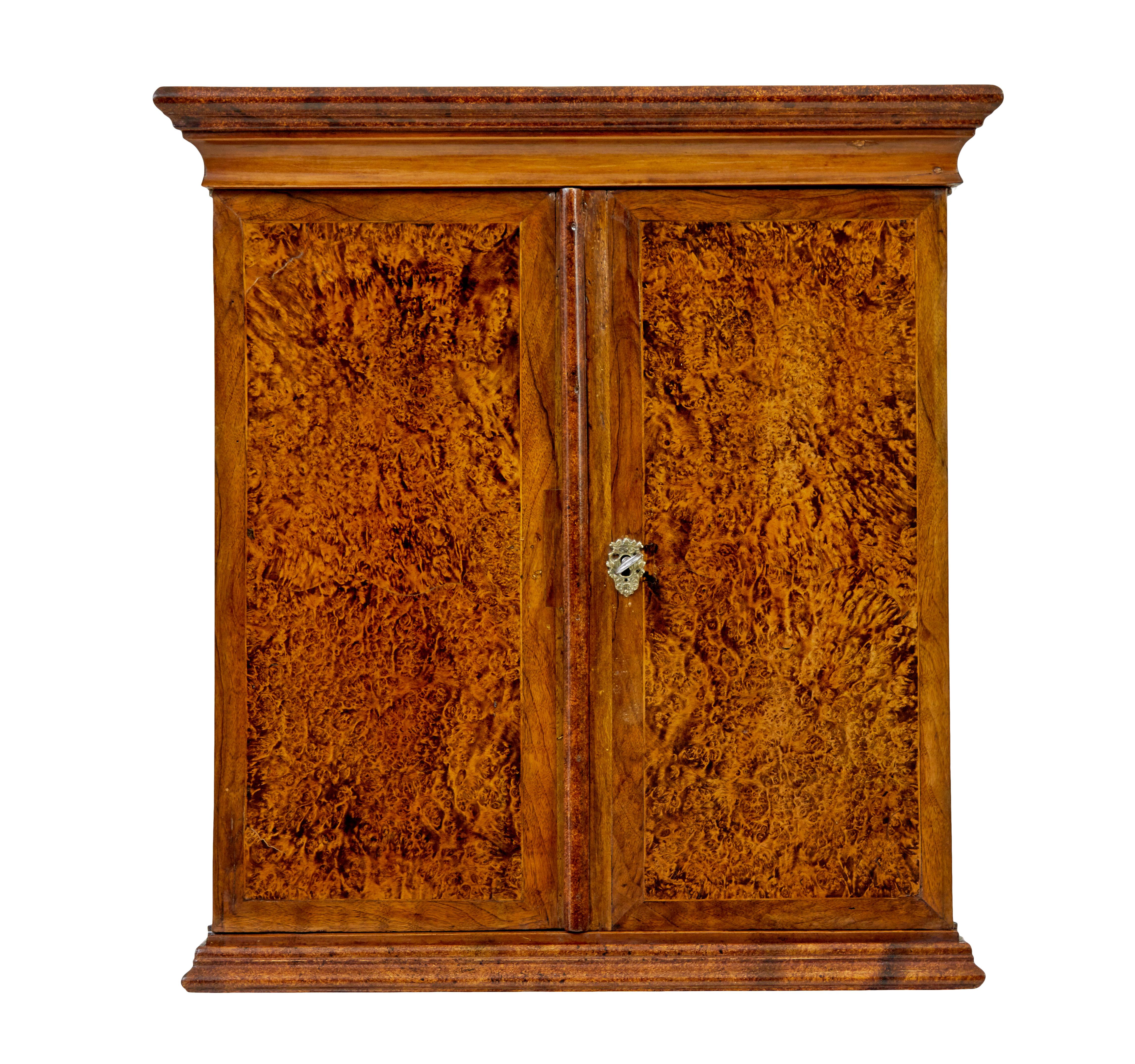 Mid 19th century Swedish alder root wall cupboard circa 1860.

Rare and stunning Swedish piece made in alder.  Cornice top and moulded edge to the bottom.  Cross banded and strung double doors open to reveal a partially fitted interior.  Later