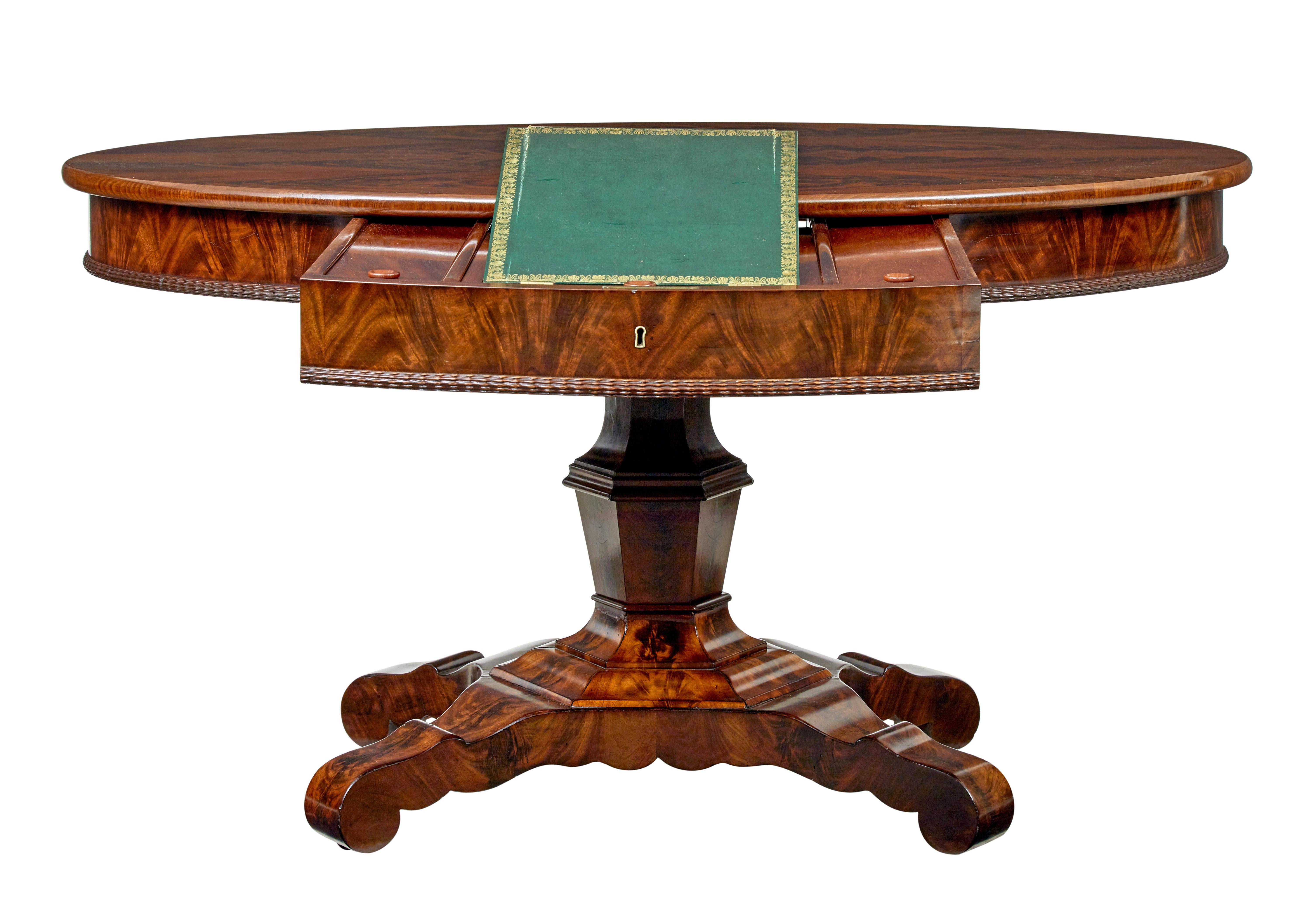 Mid 19th century center table with writing slope circa 1860.

Fine quality empire period swedish flame mahogany center table.  Oval top with the unusual feature of having a fitted writing slope in the drawer.

Oval top with arranged flame mahogany