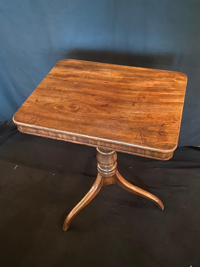 This stunningly elegant mid 19th century pedestal mahogany side table stands on three cabriole feet. The clean lines of the design allow the deep mellow tones and natural markings of the wood take centre stage. This rectangular side table with