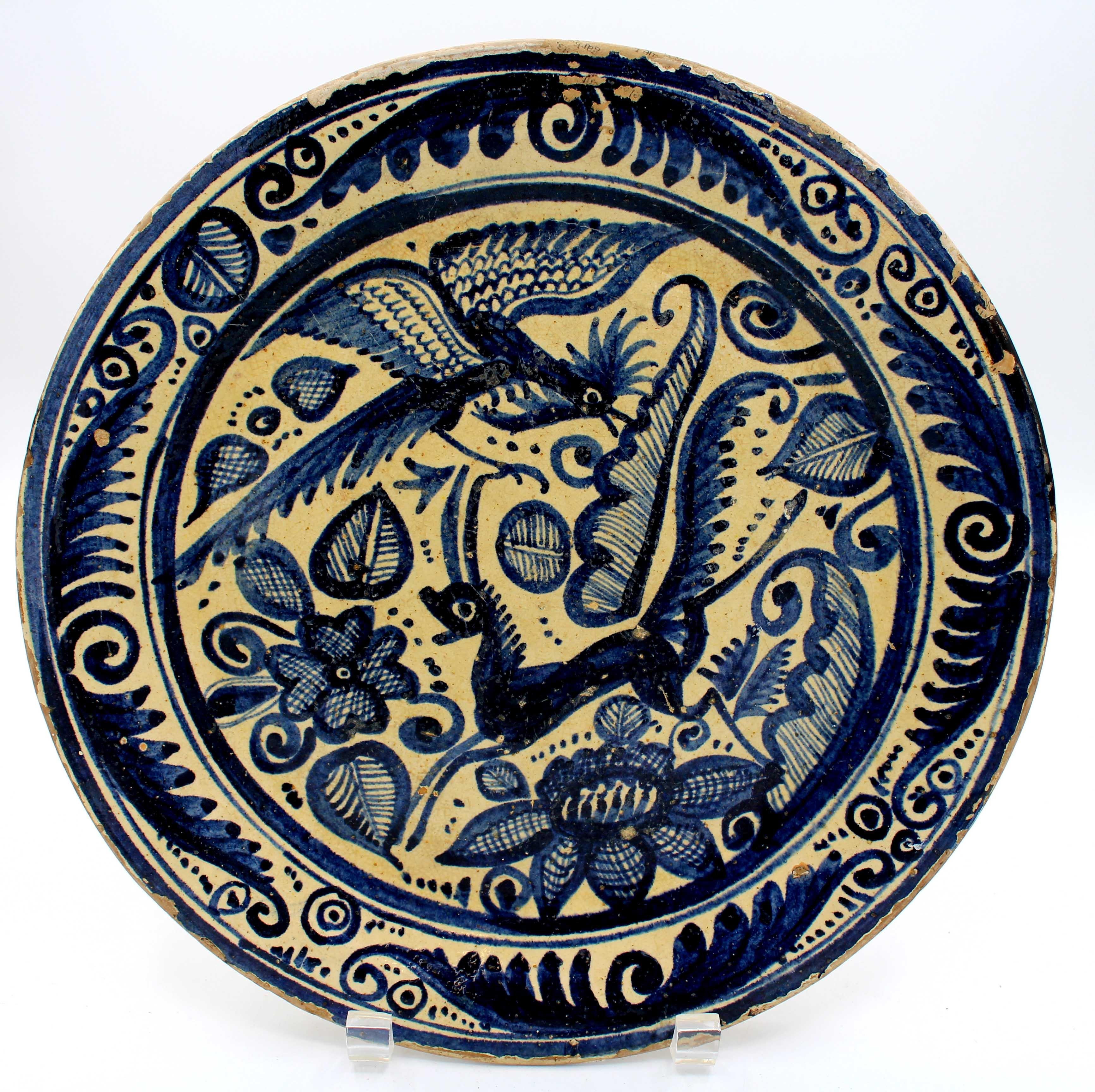 Mid-19th century tin glazed terracotta chop plate, likely Spanish. Blue & cream glazing with a fanciful bird & antelope. Edges heavily flaked. Provenance: Estate of Katherine Reid, former Director of the Cleveland Museum of Art. 11 9/16