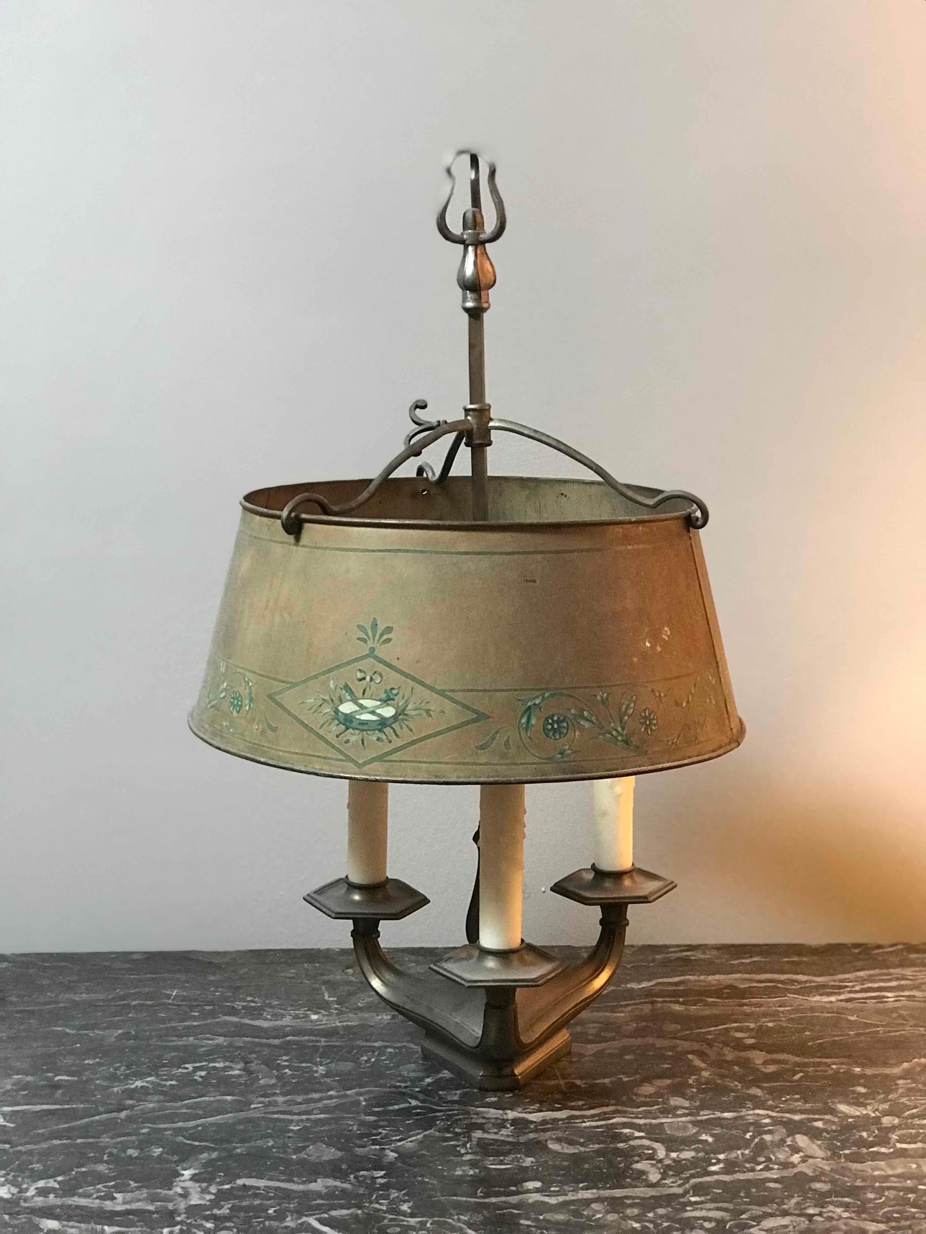 1860s French Bouillotte lamp featuring three candlesticks with brackets and a golden taupe tole shade accented by a decorative teal floral border. Bouillotte is a gambling card game that gained popularity during the early days of the French
