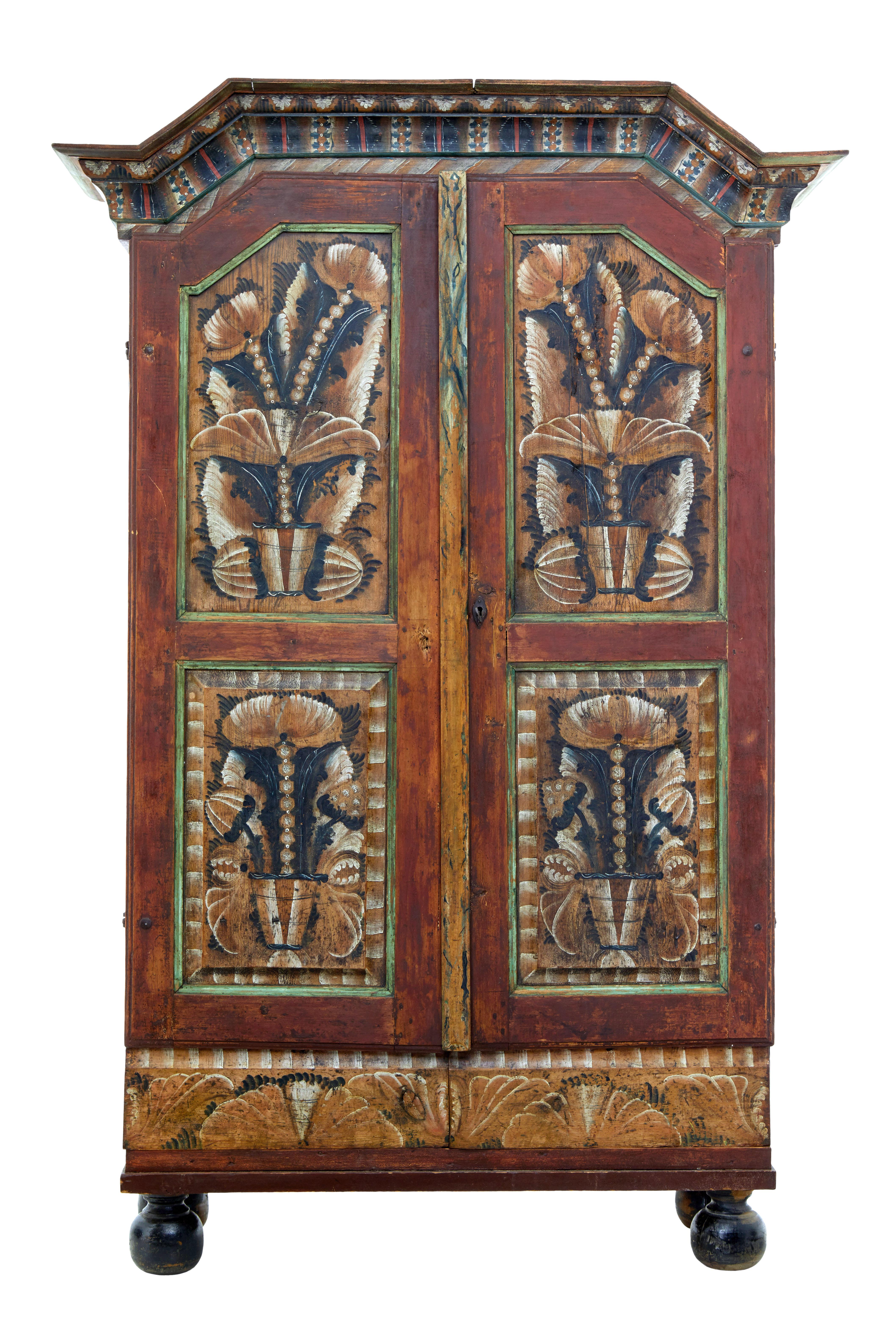 Fine quality piece of traditional Swedish painted folk art furniture, circa 1840.

Heavily hand painted front, from the cornice to the bottom drawers. Shaped cornice below which the double doors open to reveal a fixed shelf interior of 4 shelves.