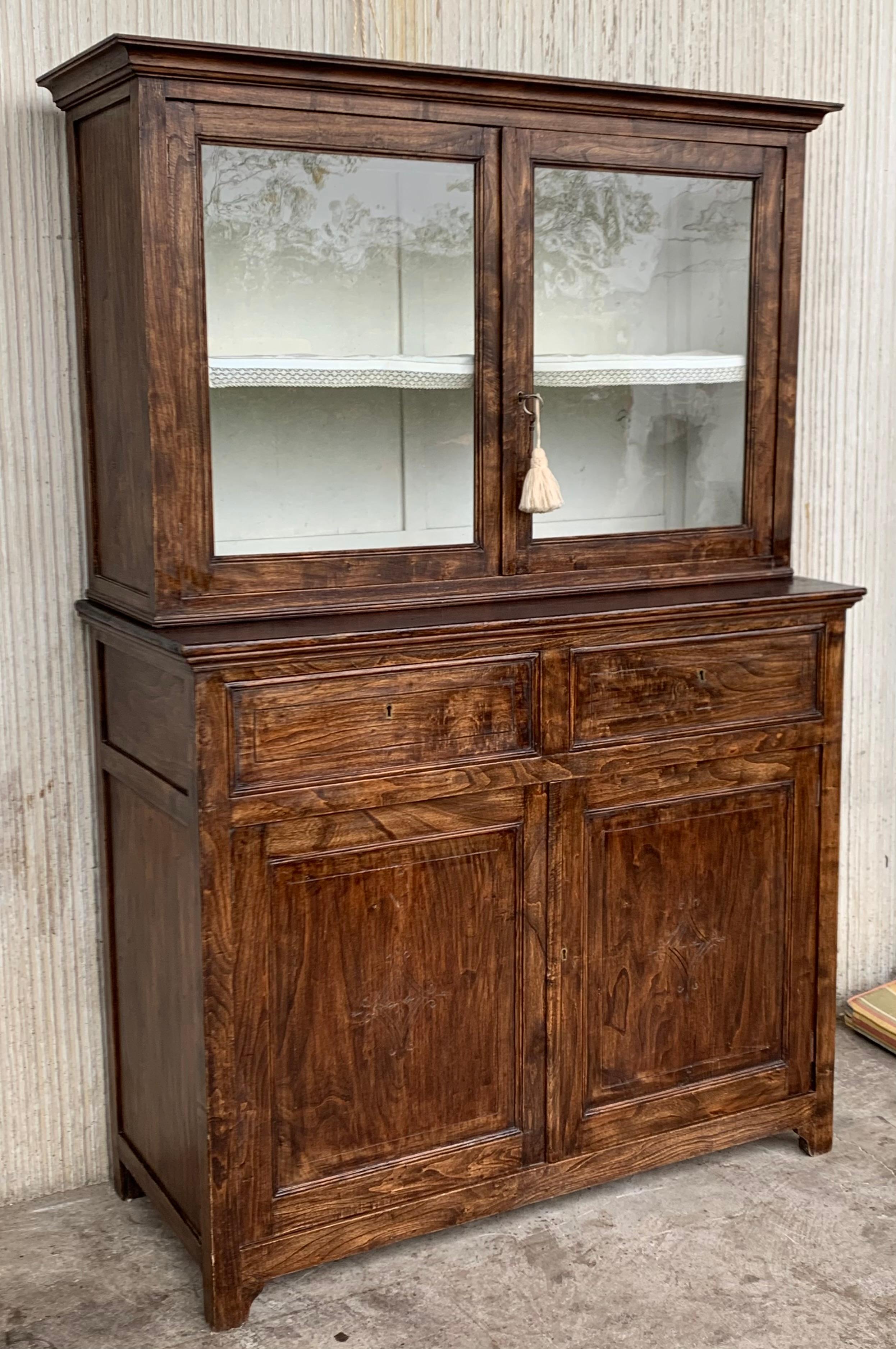 Beautiful married step back walnut pie safe cupboard with glazed doors, probably from France, mid 19th century. The upper section with cornice molding and two glazed doors surmounting a lower case with two drawers over two doors and ends with