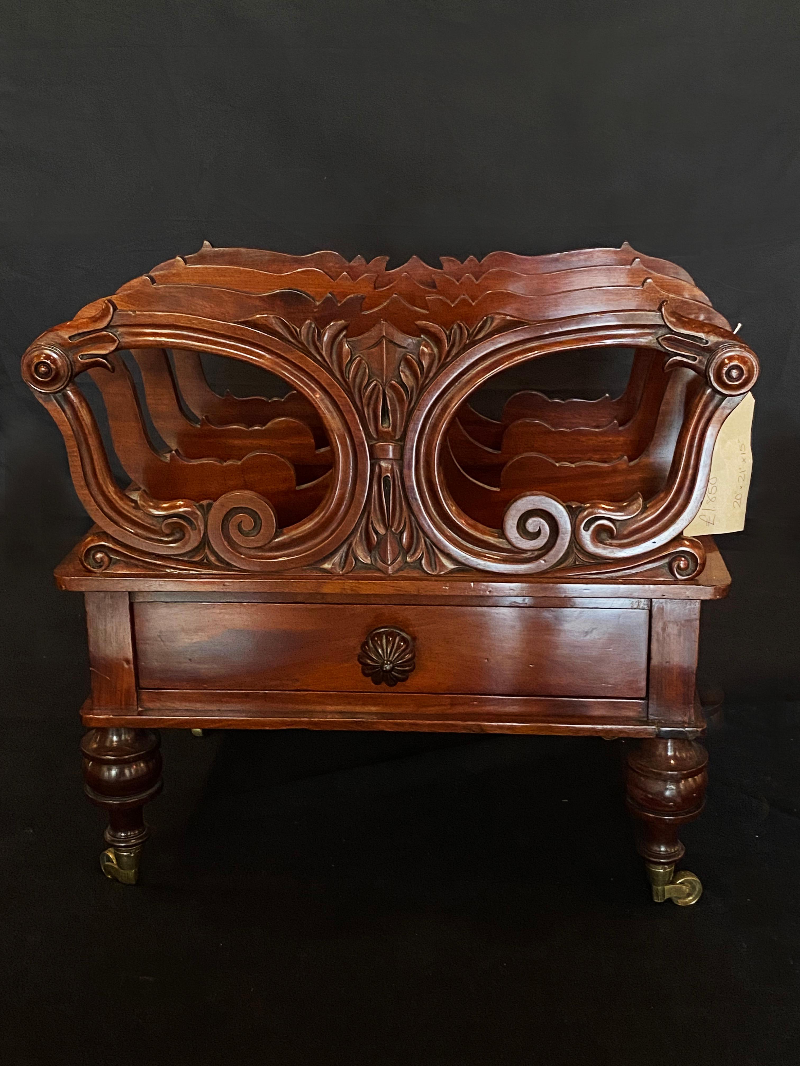 An incredibly handsome early Victorian mahogany canterbury. With four shaped pierced dividers, joined by turned balusters, above a cavetto-moulded plinth, enclosing a mahogany frieze drawer on bun legs and brass castors.