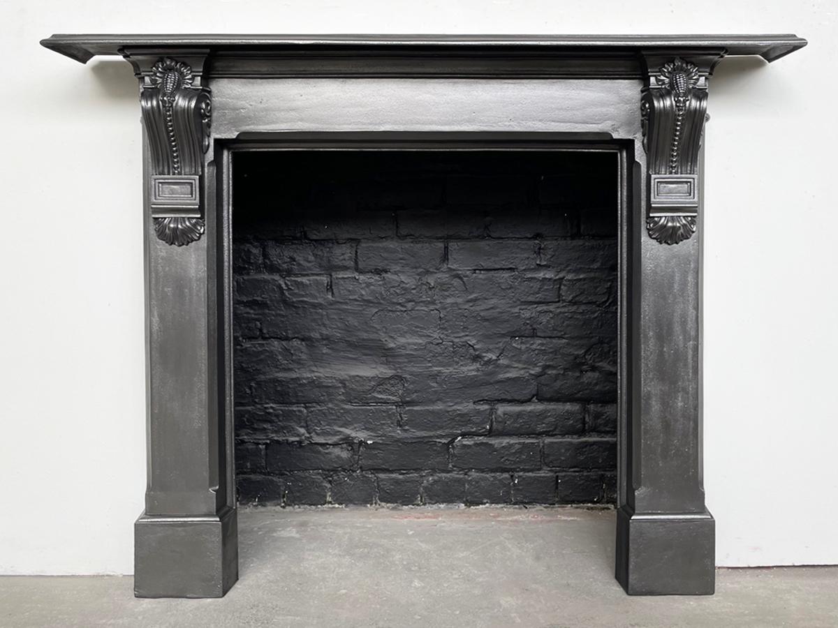 Mid 19th century Victorian cast iron fireplace surround with decorative cast corbels supporting the shelf. Circa 1860.

This surround has been finished with traditional black grate polish to leave a gun metal appearance.

For detailed sizes see