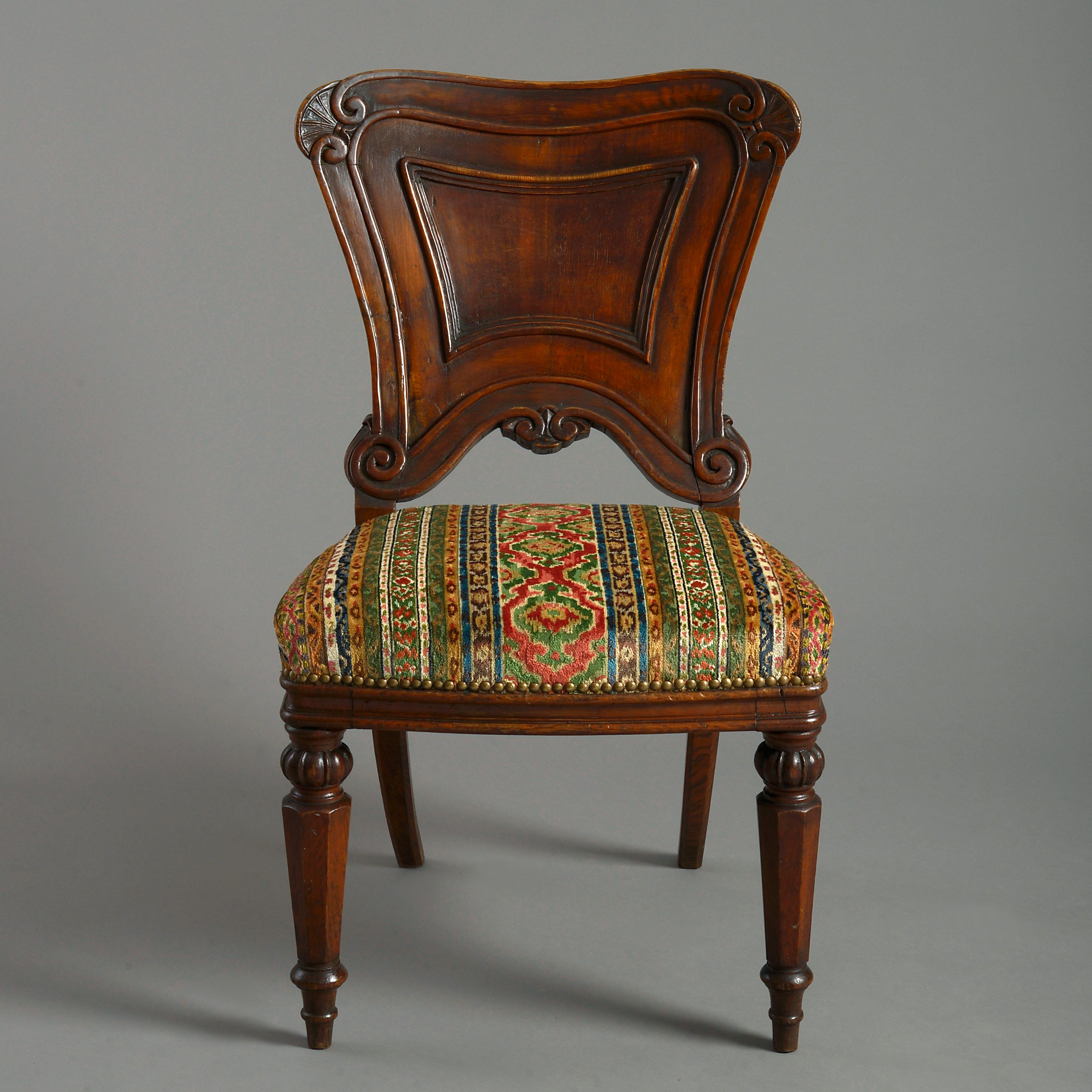 A mid-19th century Victorian Period oak side chair, the generously carved cartouche back set upon an upholstered seat and raised upon faceted turned legs.

Upholstered with Brunschwig & Fils Savonnerie Velvet Fresco Fabric.