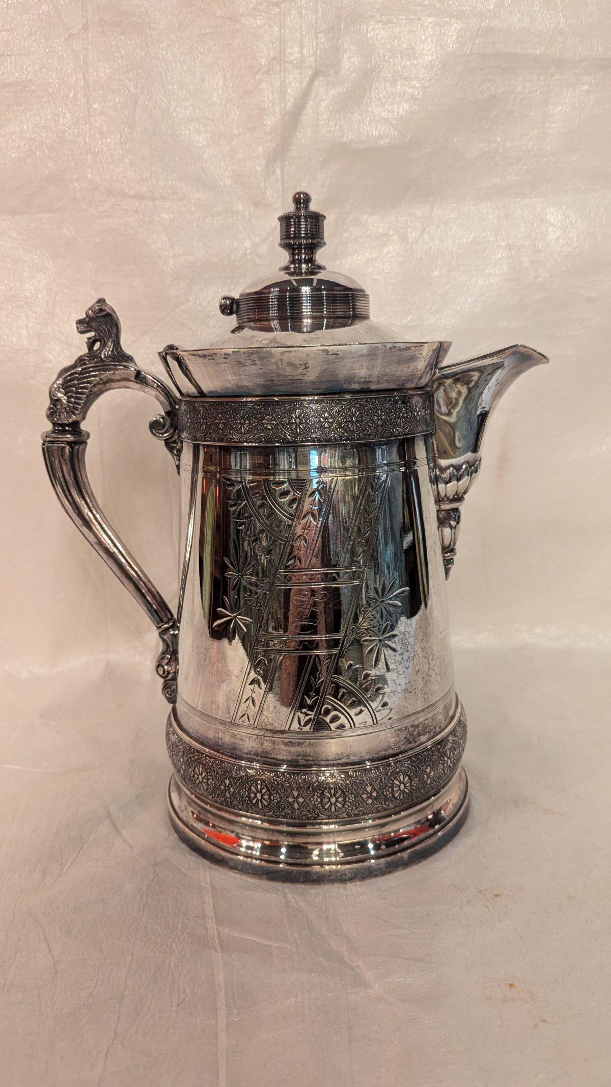 Pichet victorien en métal argenté avec une belle brillance et des tracés complexes sur toute la surface, avec une anse en forme de tête de lion. Il s'agit d'un grand pichet de 6,5 pouces de circonférence, 10 pouces de l'anse au bec, 12,5 pouces de