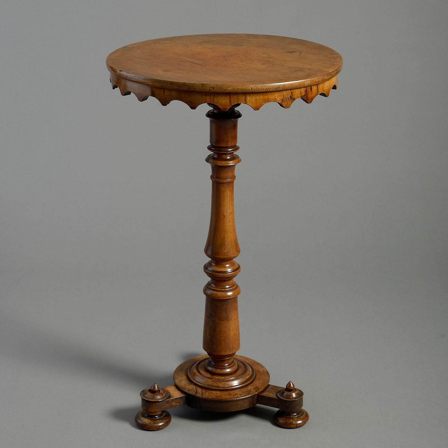 A fine mid-19th century Victorian Period walnut occasional table, the circular top with inverted scalloped apron set upon a turned stem, the base comprising a central roundel raised on three turned feet each surmounted with a finial.

This table