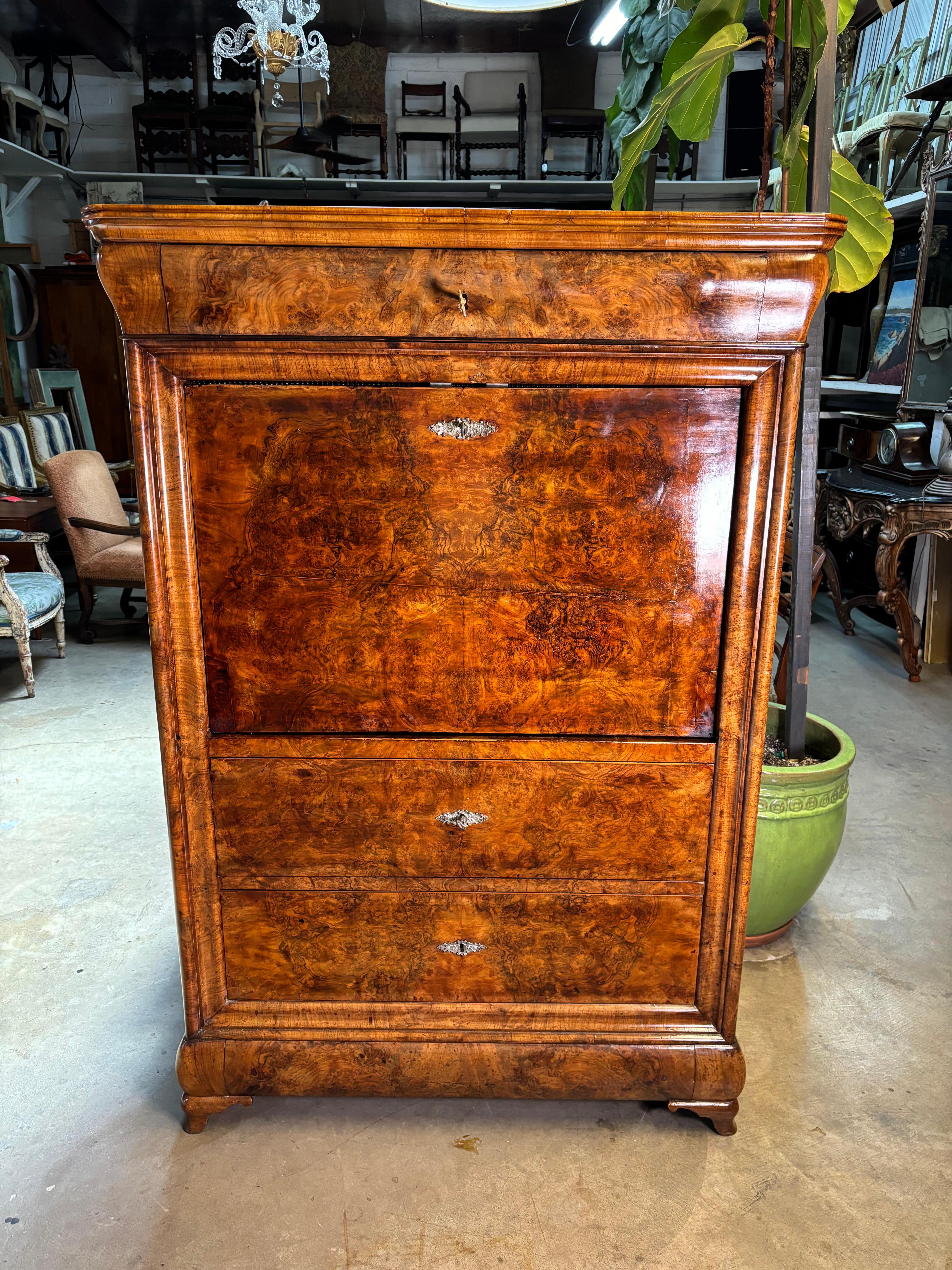 Magnifique commode secrétaire du milieu du 19e siècle, vers 1841, à dessus incliné, en acajou et noyer figuré assorti. Comprend deux grands tiroirs inférieurs et un tiroir convexe à arc secret tout en bas. Elle repose sur des pieds fuselés en noyer.