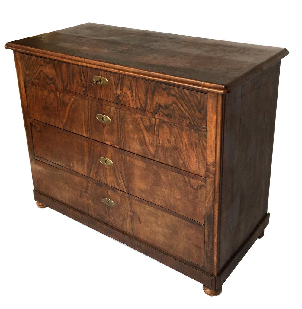 Commode à quatre tiroirs de style Biedermeier tardif, vers les années 1840, en placage de noyer avec des montures de bronze ovales élaborées. Cette commode est un bel exemple du style de mobilier Biedermeier tardif qui combine un cadre rigide doublé