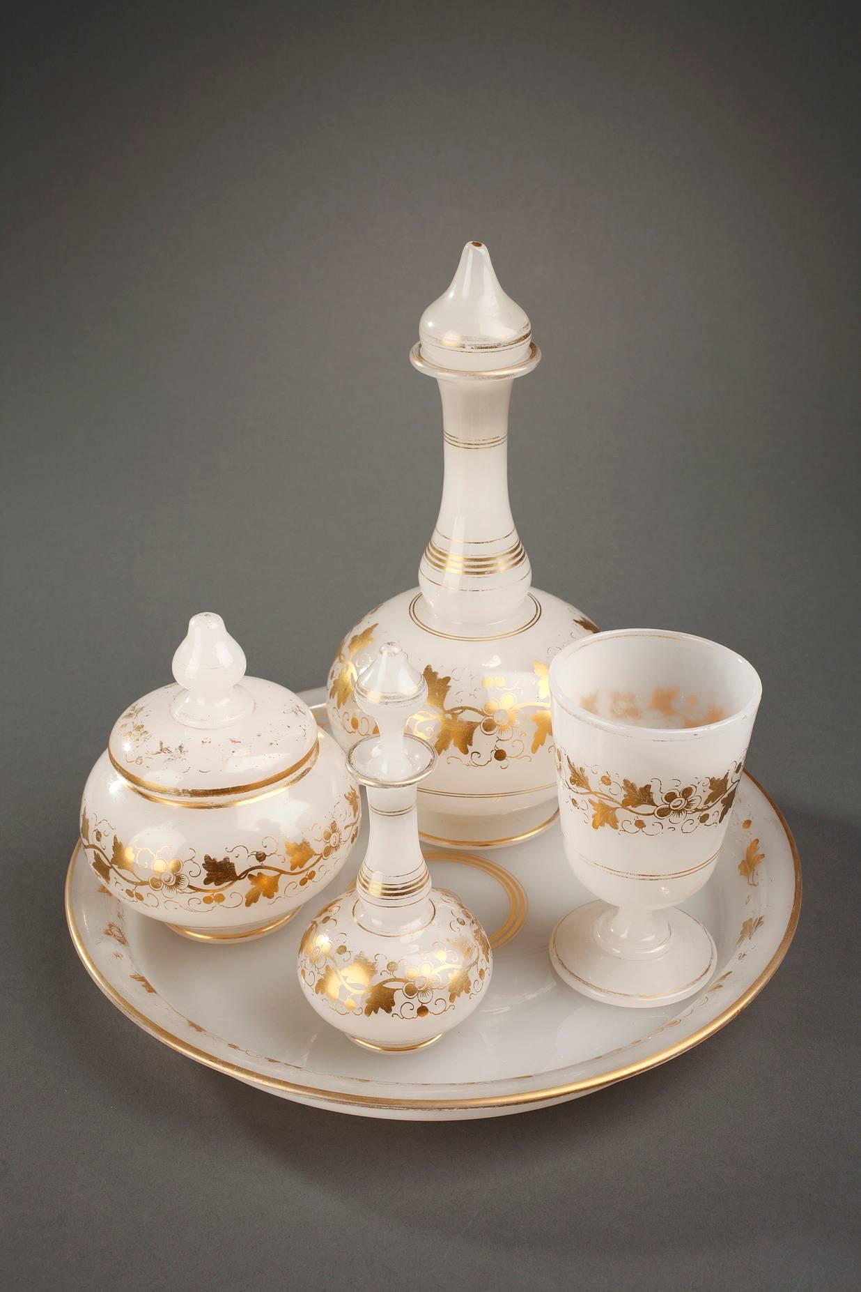 White opaline water set highlighted with golden stripes, garlands of plants, and small flowers. The set is composed of a round tray, a glass, a sugar bowl, a jug and a flask with their pointed stoppers. Beautiful quality of glass and delicately