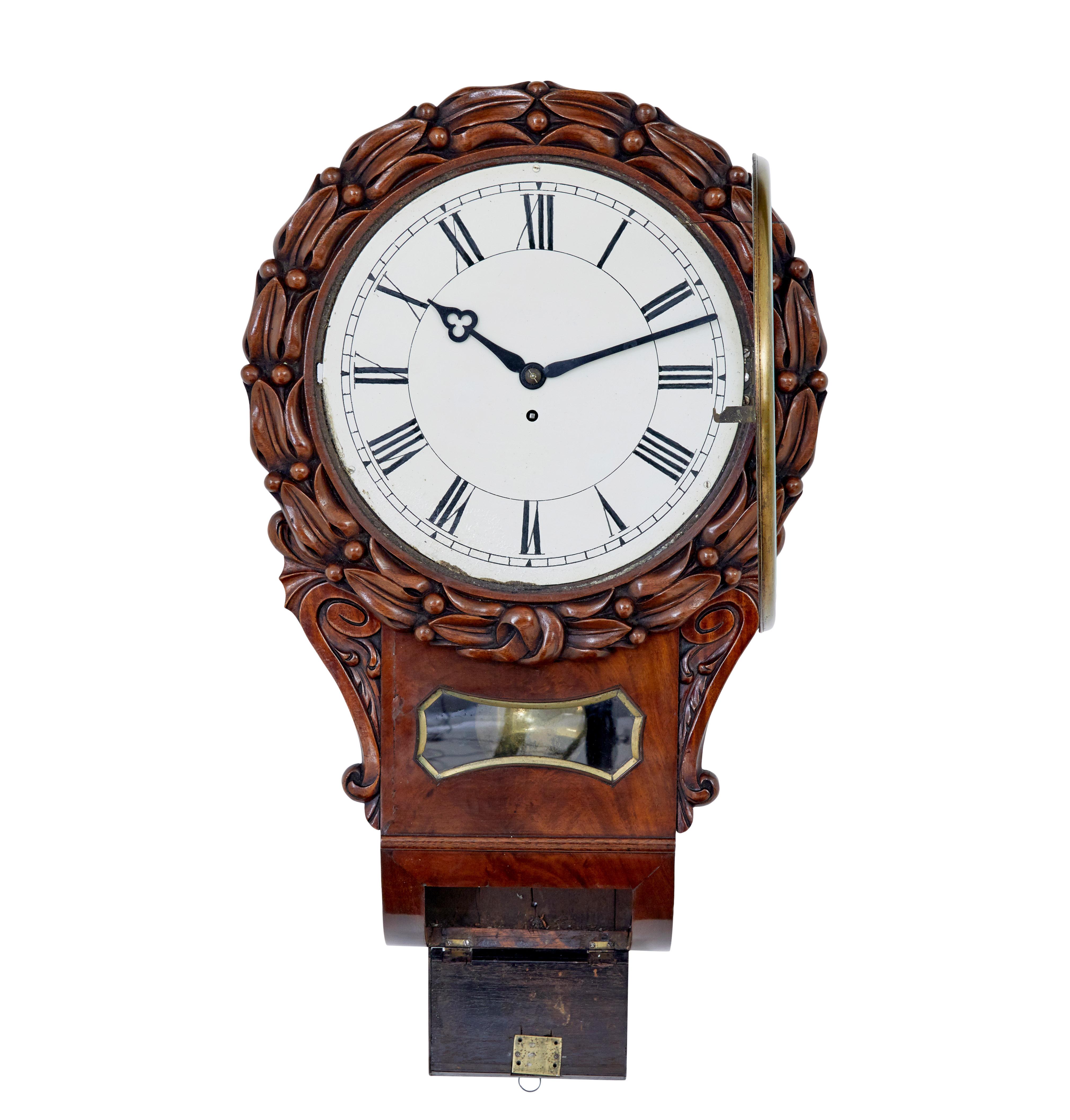 Mid 19th Victorian century mahogany fusee wall clock circa 1860.

Good quality English wall clock from the high victorian period.  White enamel dial with roman numerals, glass door with brass bevelled surround.  Dial decorated with carved flowers