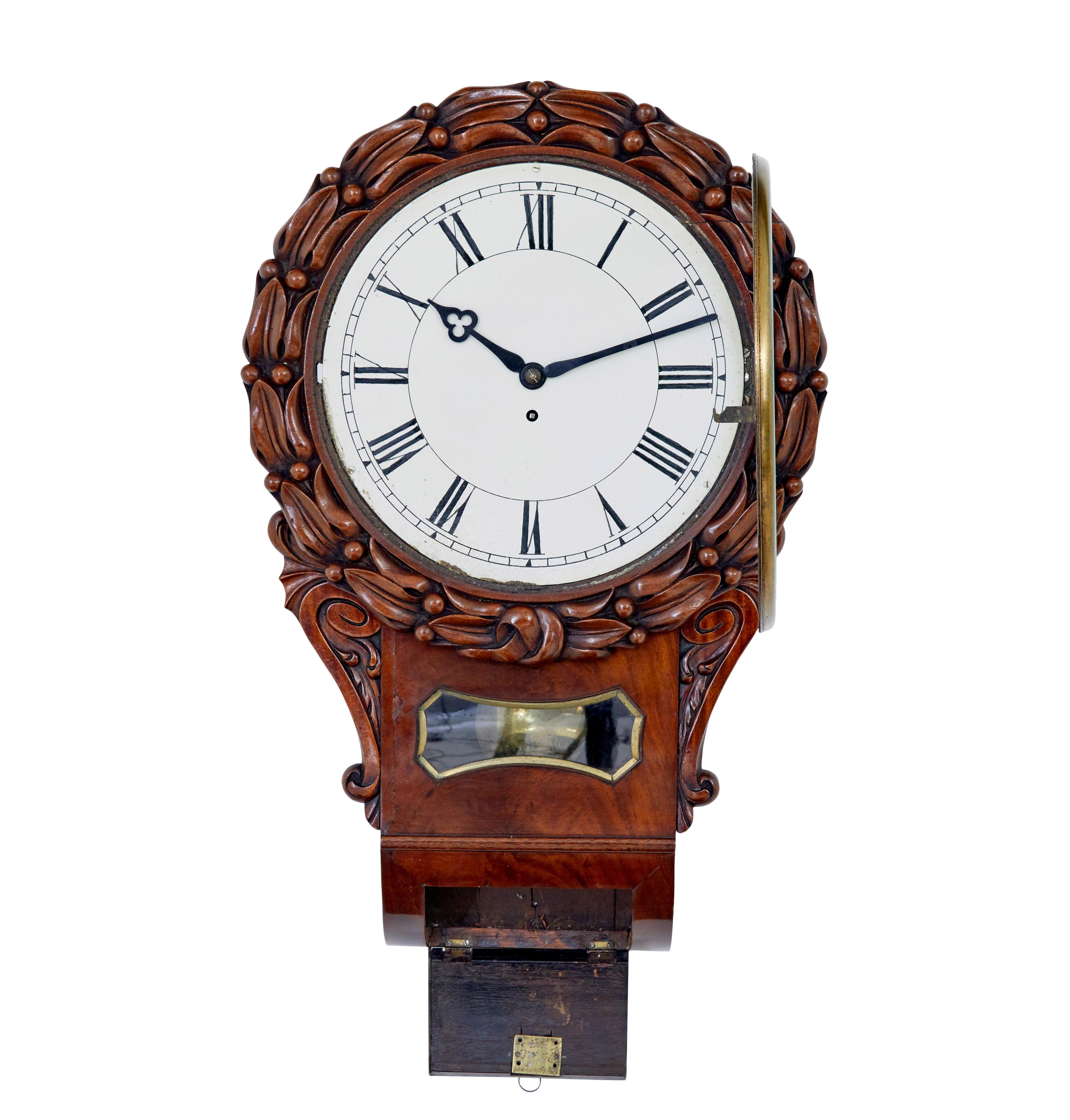 Mid 19th victorian century mahogany fusee wall clock circa 1860.

Good quality English wall clock from the high Victorian period.  White enamel dial with roman numerals, glass door with brass bevelled surround.  Dial decorated with carved flowers