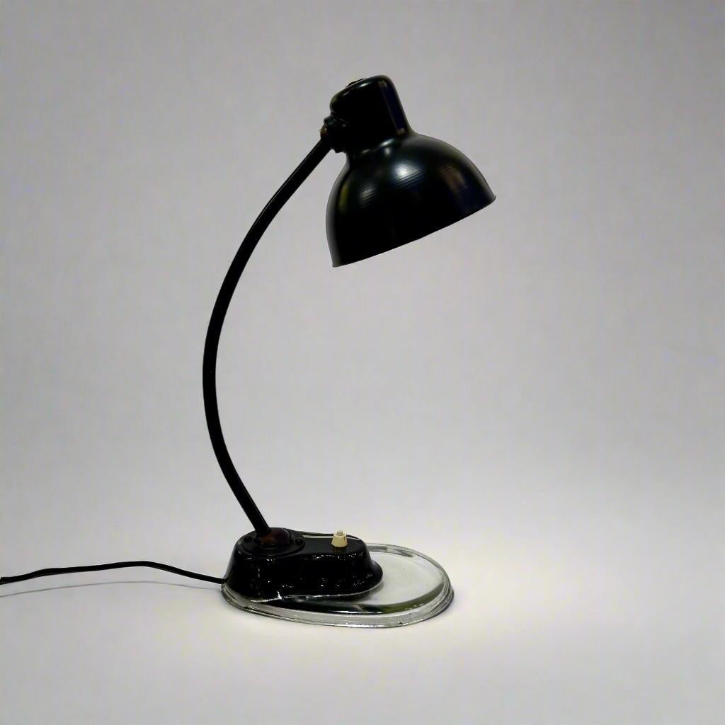 Lampe de bureau conçue par Marianne Brandt en Allemagne, années 1930.  Fabriqué en acier peint en noir avec des accents en bakélite reposant sur une base en lucite transparente. L'abat-jour en acier peut pivoter pour une utilisation ponctuelle.  Le